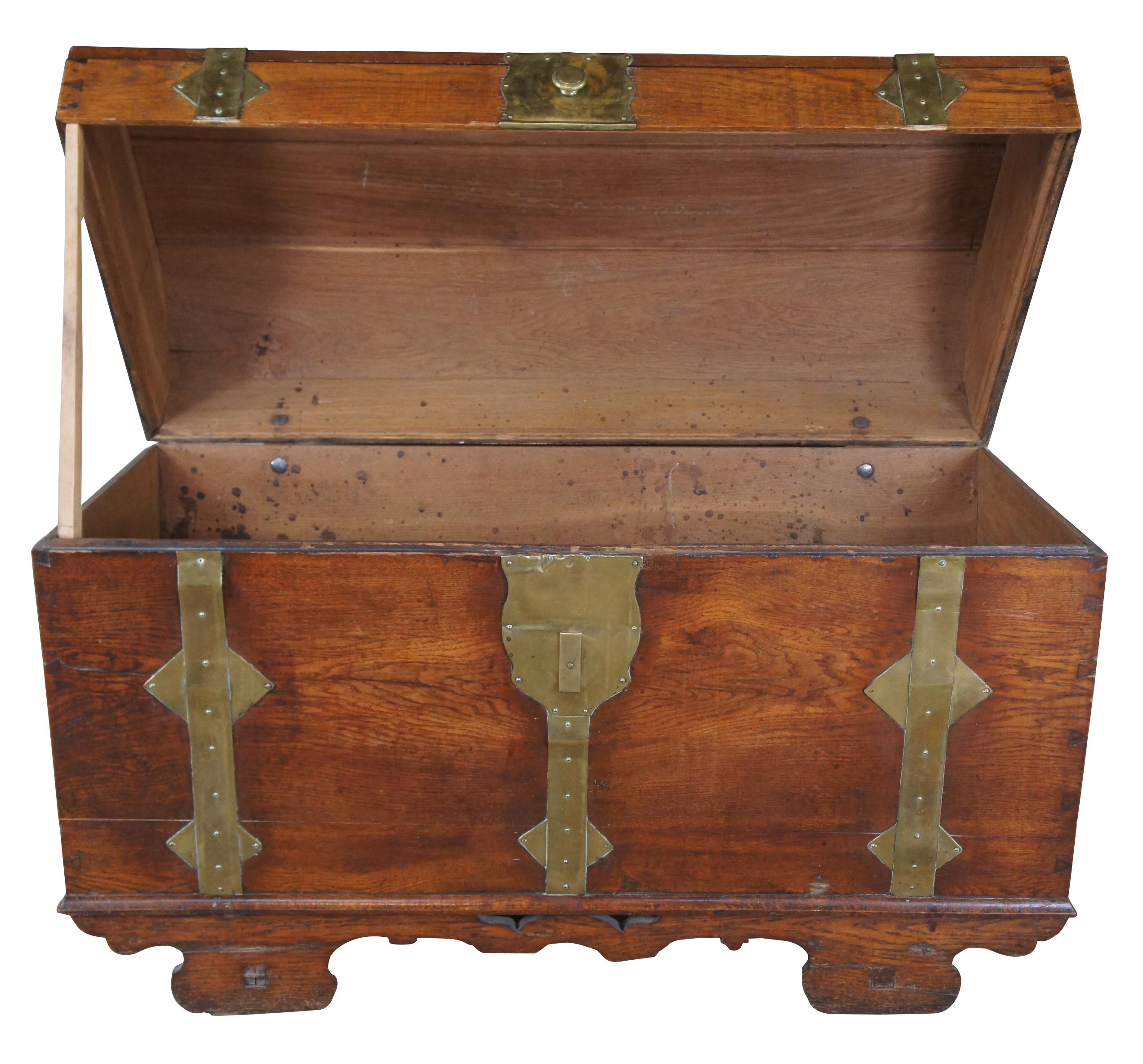An extraordinary and extremely rare primitive early 18th Century Baroque trunk or chest.  Made of oak featuring a domed top with brass bound hardware and pegged wood wheels.  Includes hand dovetailing and forged brass handles.  
 