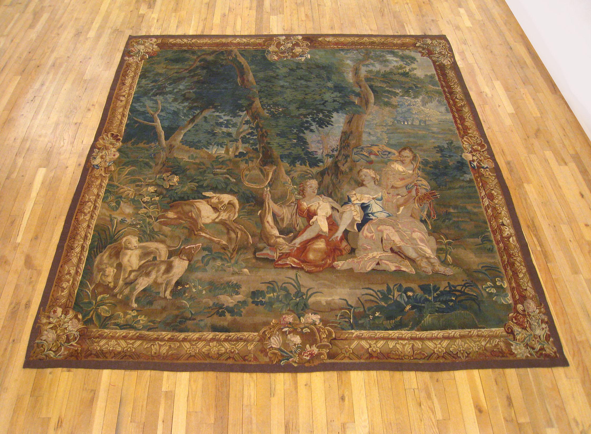 An 18th century Brussels mythological hunting tapestry, size 9' H x 8' W, depicting the Roman goddess of the hunt, Diana, reposing in a forest setting with her attendants, with one holding Diana's bow and arrow, and with her Horn hanging from a tree