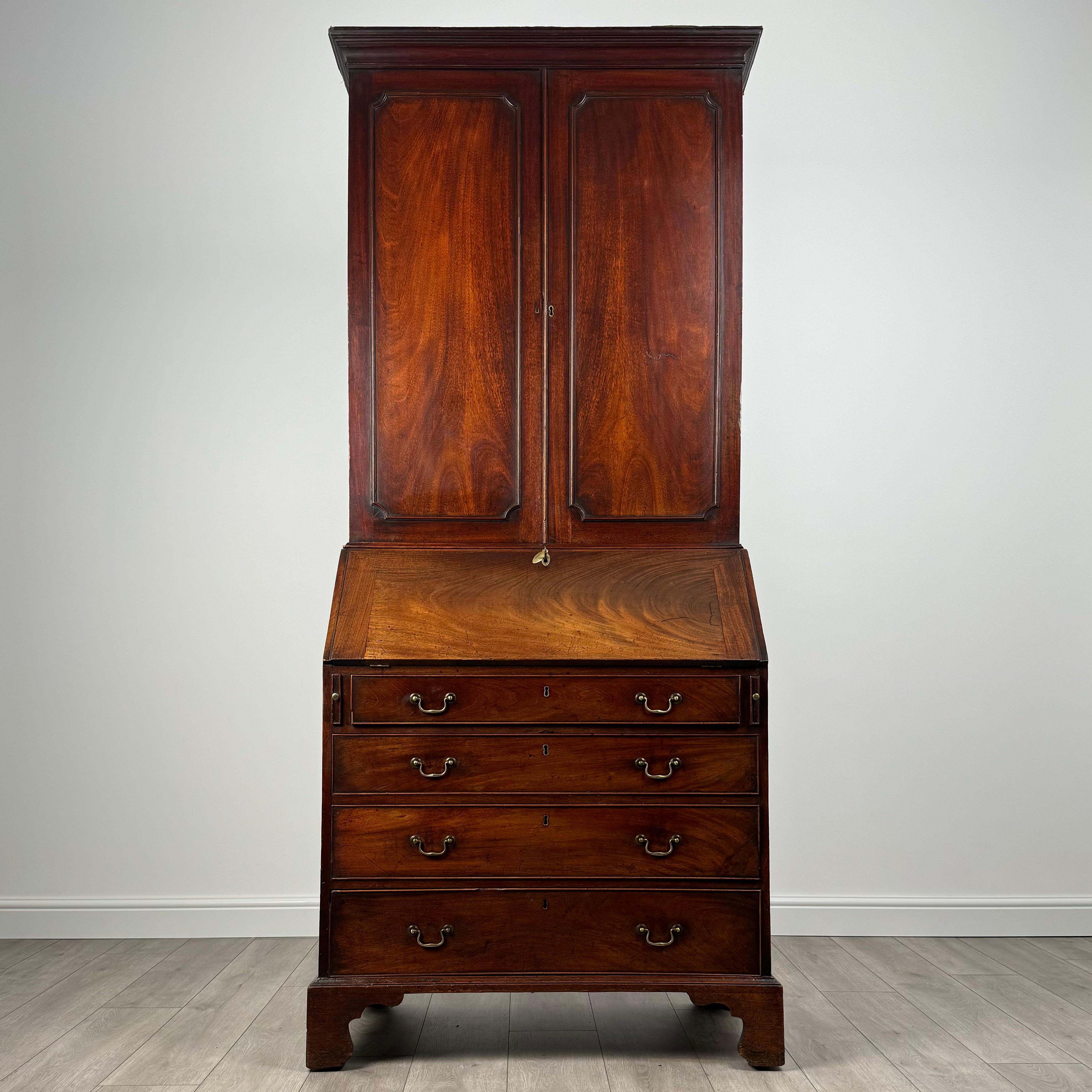 Cette exquise bibliothèque-bureau antique du XVIIIe siècle est un meuble remarquable, fabriqué de manière experte en acajou fin et d'une qualité exceptionnelle. 
Posée sur d'élégants pieds crochets, cette bibliothèque-bureau est à la fois