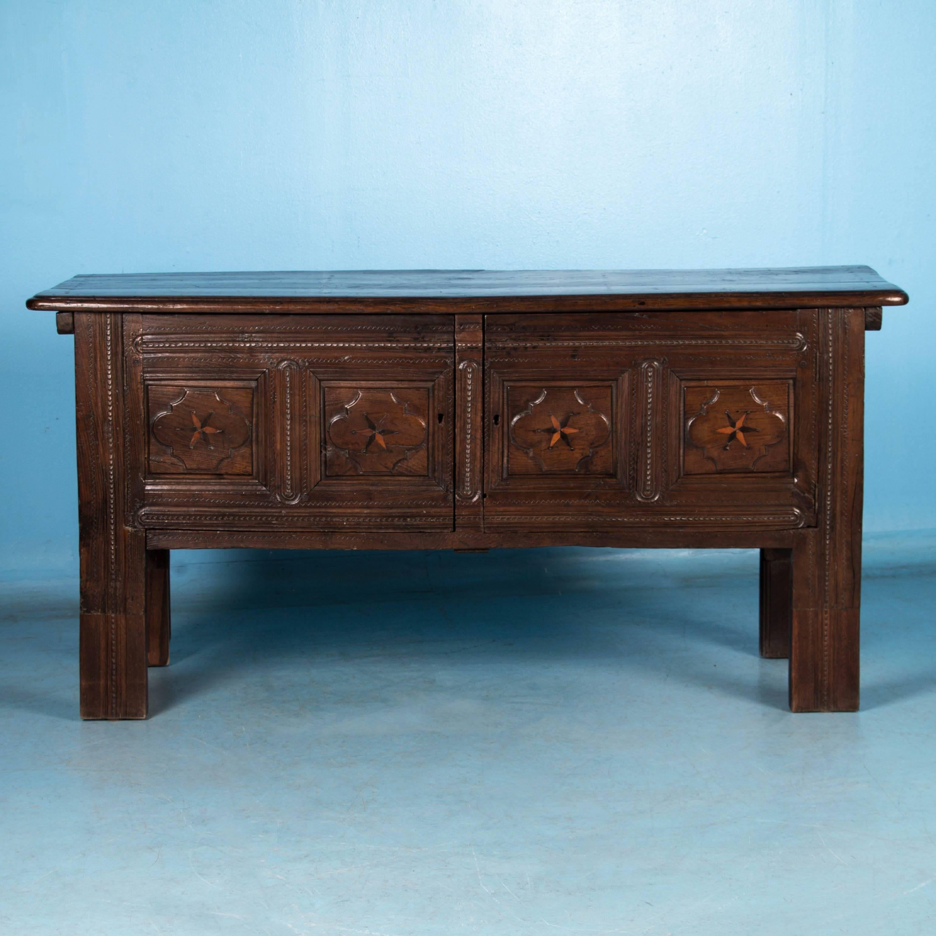The raised panels with inlay of contrasting wood and the rich brown oak color add to the appeal of this late 19th century Georgian cabinet. Originally lower to the ground, about 8 inches has been added to the legs to achieve the height of a server