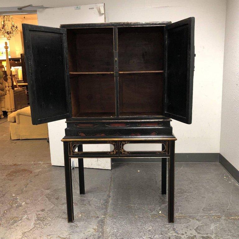 An antique Chinese cabinet. The cabinet itself is believed to be, circa 18th century. The stand is much later. Two swing open doors to reveal an inner shelf. Original Price: $10,253.