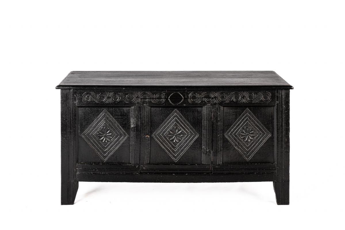 This English chest is a beautiful example of traditional craftsmanship. It was  stained dark brown, almost black, and with visible signs of wear that speak to its long history. Originally, this piece was a storage chest, commonly found in English
