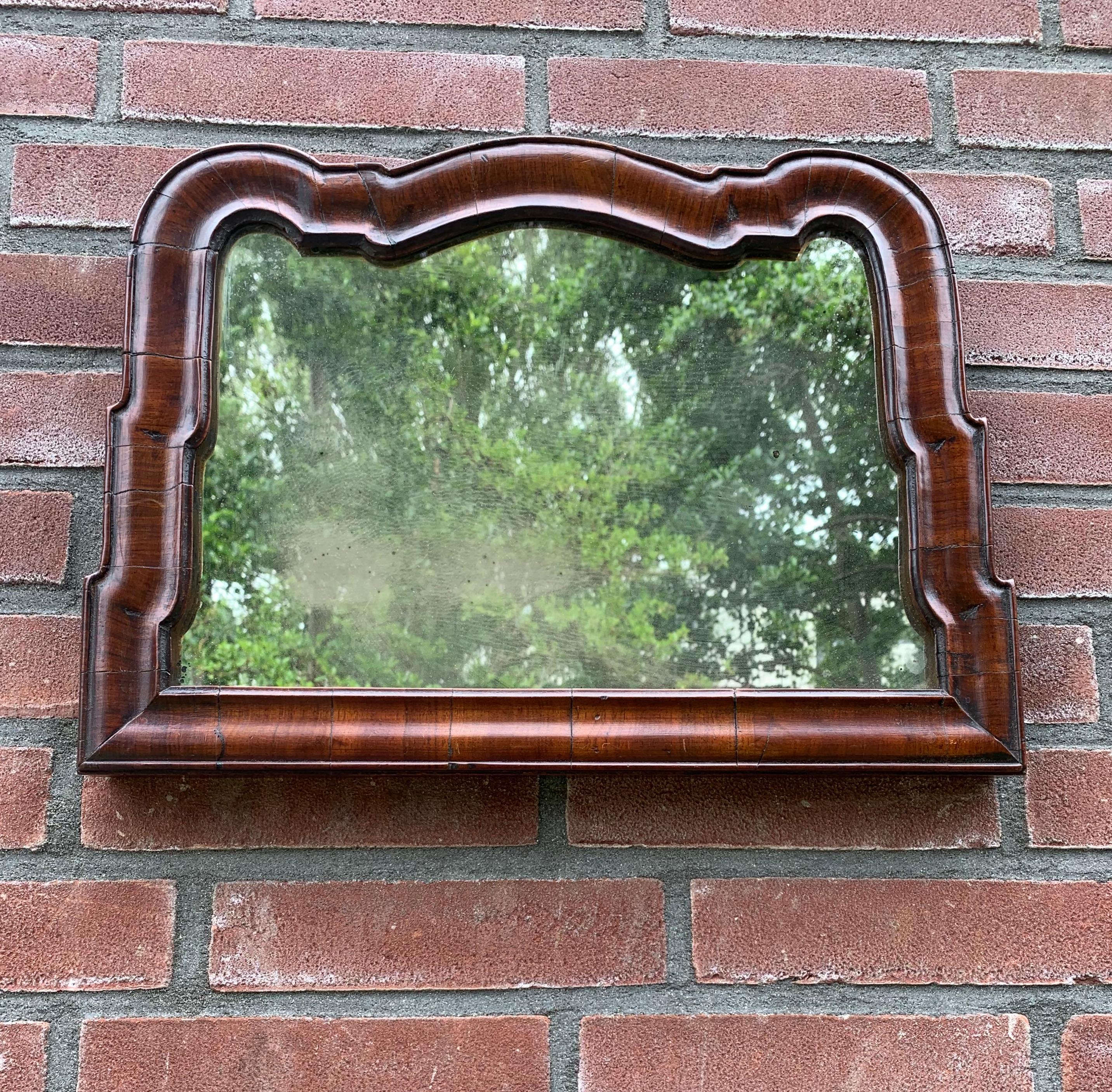 Small size and stunning mirror from the late 1700s.

This very old wall mirror has a truly wonderful shape and patina. The rich warm color (also known as patina) is what attracts enthousiast from all over the world to antique pieces, because it