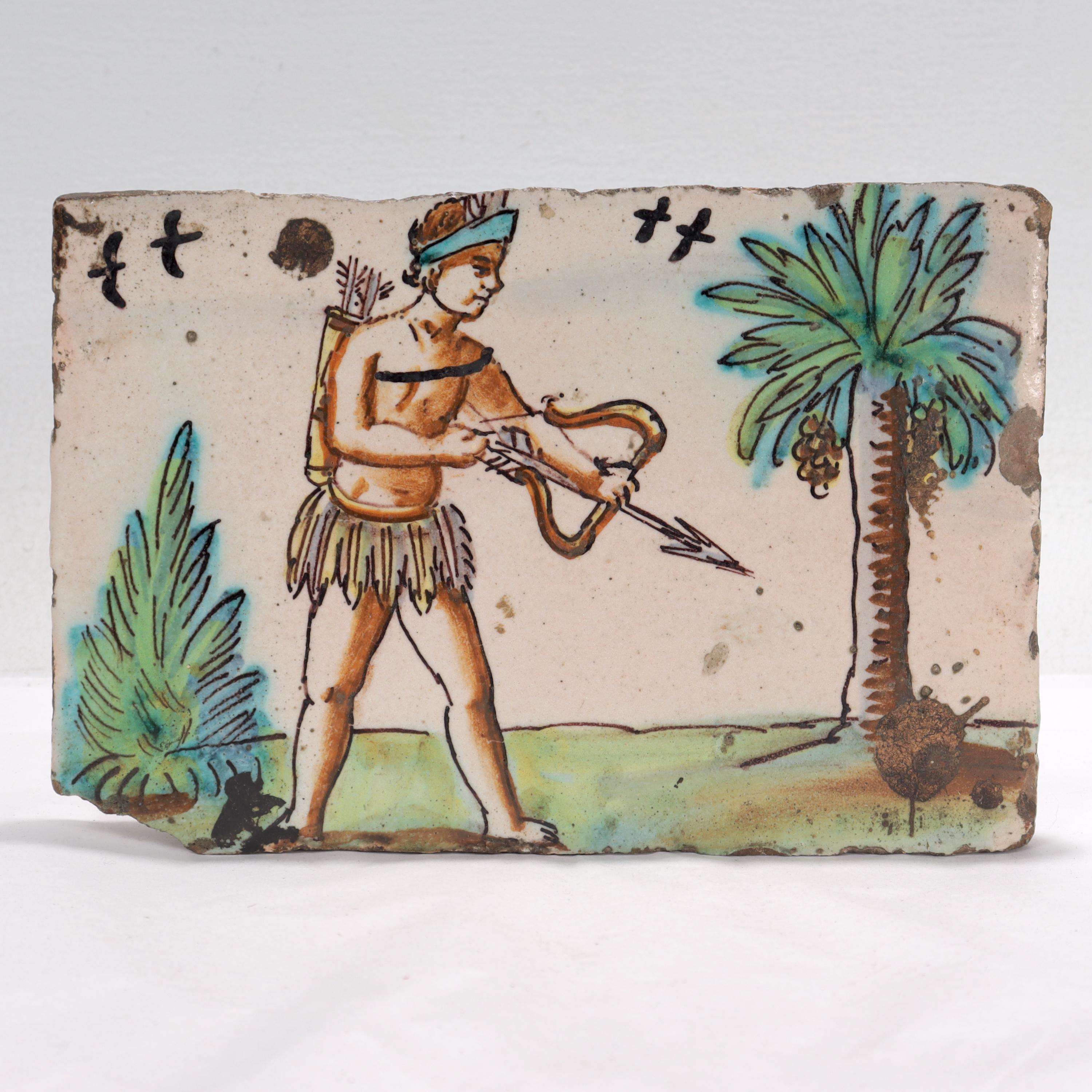 Un beau carreau de poterie antique du 18e siècle.

En terre cuite.

Représentation de ce qui semble être un archer amérindien dans une jupe d'herbe avec des oiseaux et des plantes en arrière-plan.

Probablement d'origine néerlandaise.

Tout