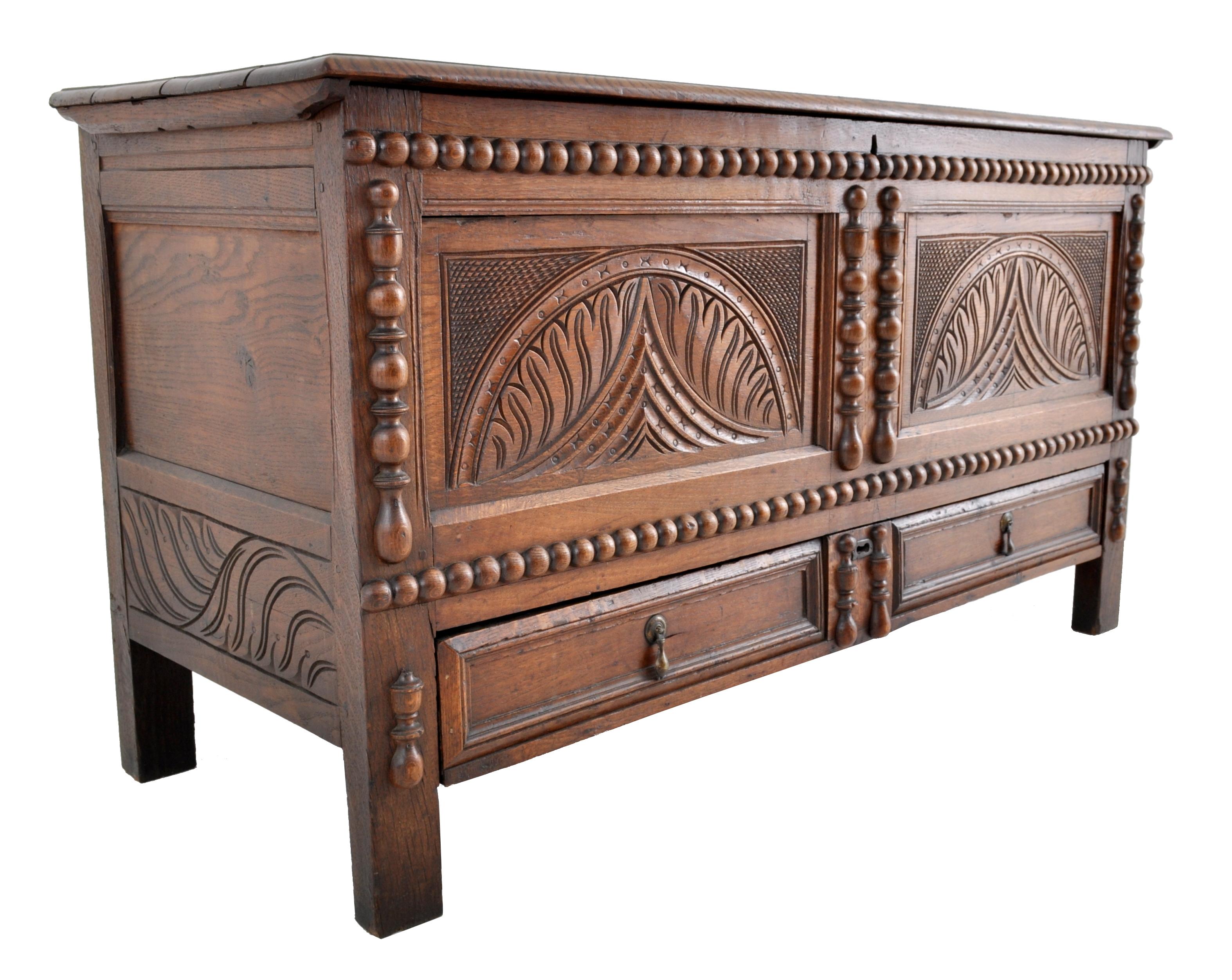 Antique 18th century English carved oak William & Mary Mule chest / coffer, circa 1720. The chest having a lift-up hinged lid, the front carved with stylized pineapples and flanked on all sides with bobbin-turned carved appliqués. The chest having
