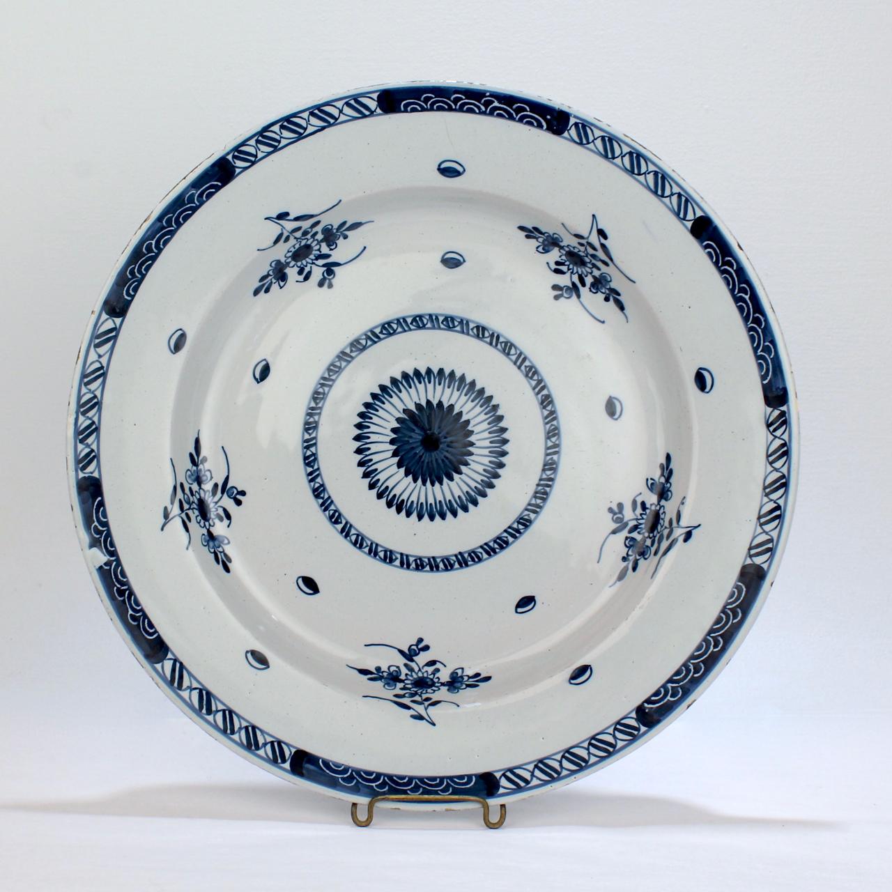 Un beau chargeur anglais de Delft.

Avec un fleuron central stylisé ou un rayon de soleil, des fleurs en éventail et des bordures géométriques.

Tout simplement une merveilleuse pièce de poterie anglaise de Delft !

Date :
Milieu du 18e siècle

État