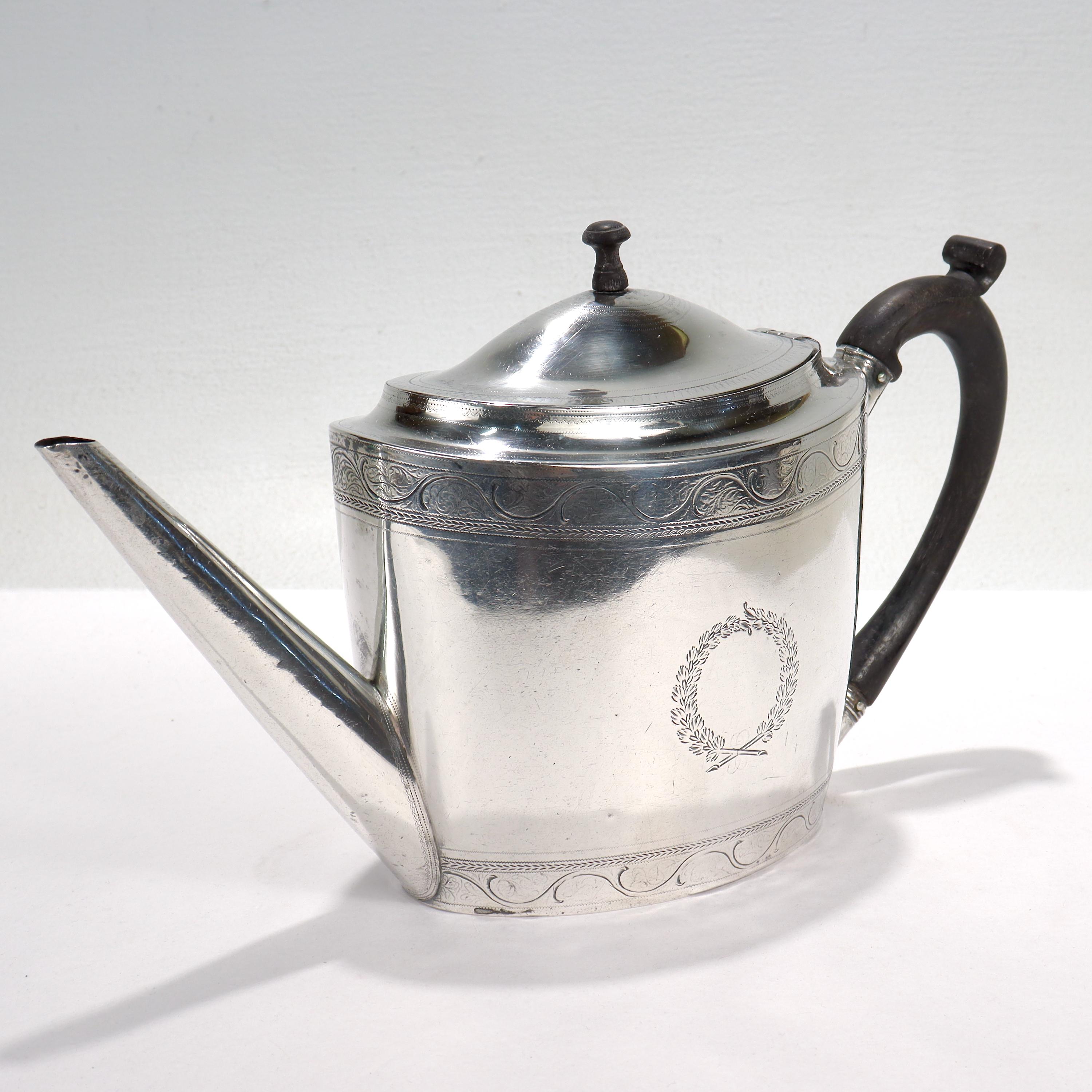 A fine antique Georgian teapot.

In sterling silver.

By Henry Chawmer & John Emes of London, England. 

Each side of the teapot is engraved wreath shaped cartouche. The top and bottom are decorated with engraved linework around the circumference,