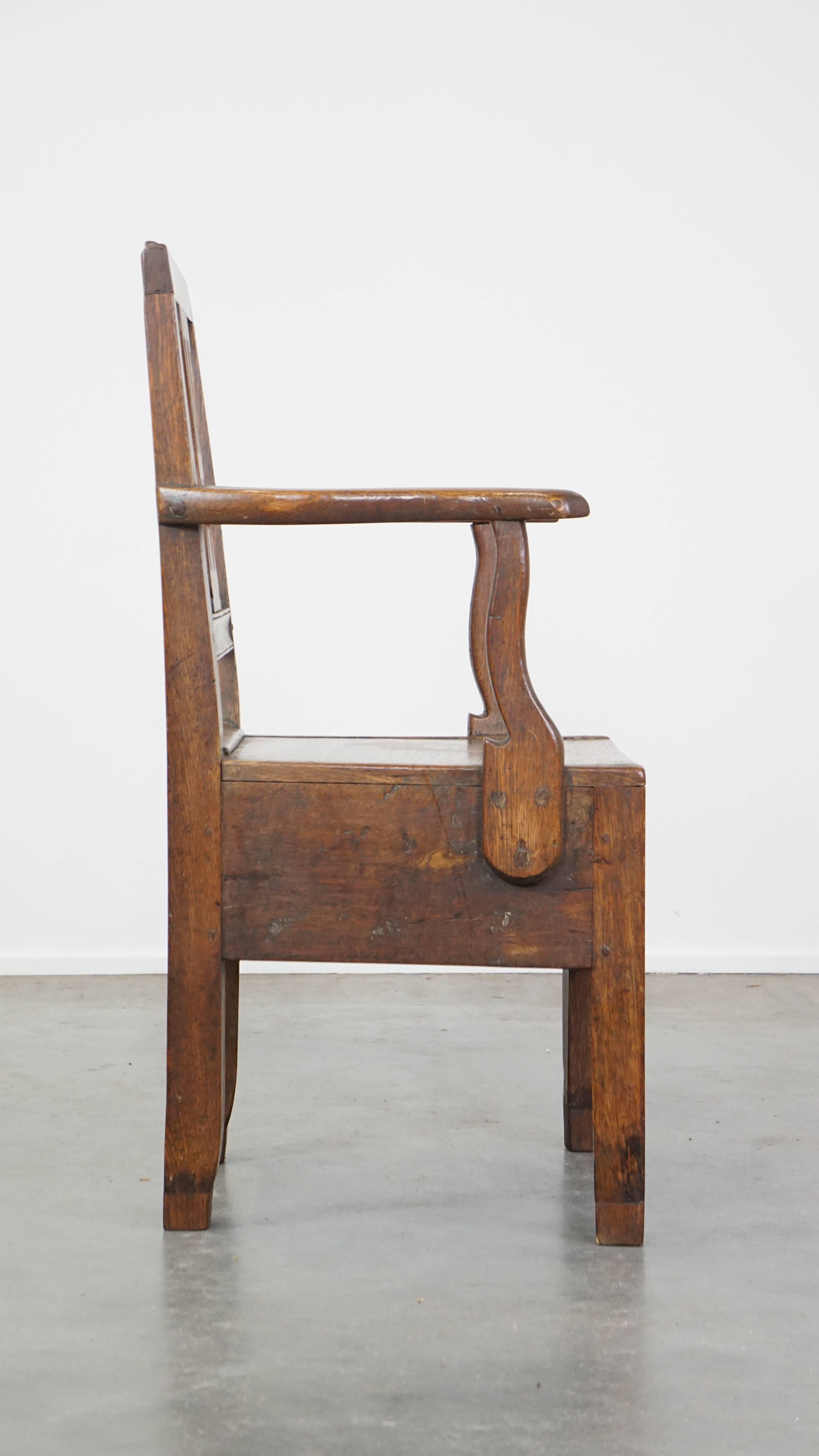 Hand-Crafted Antique 18th-century English oak armchair with armrests and an ornament For Sale