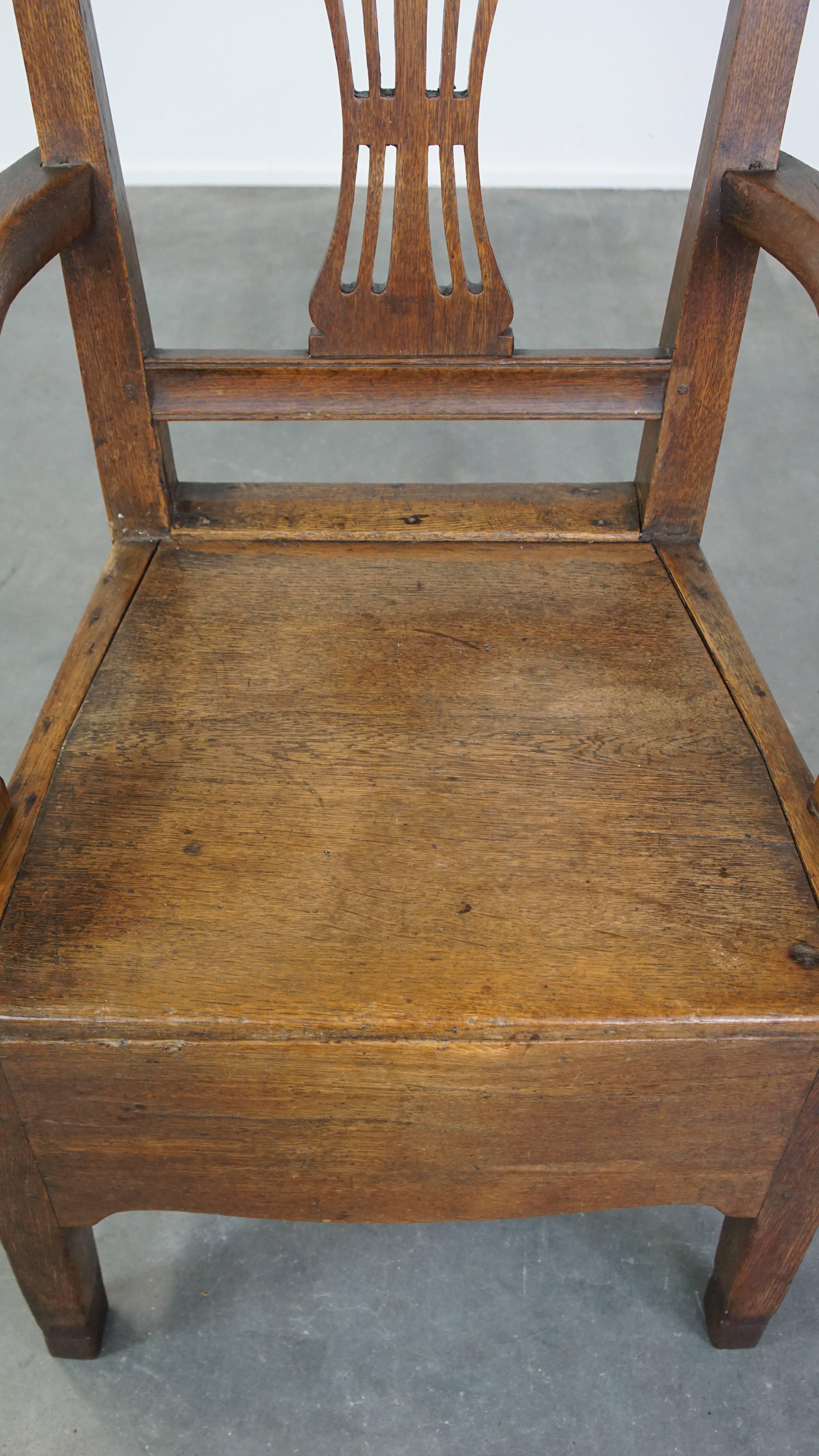 Wood Antique 18th-century English oak armchair with armrests and an ornament For Sale