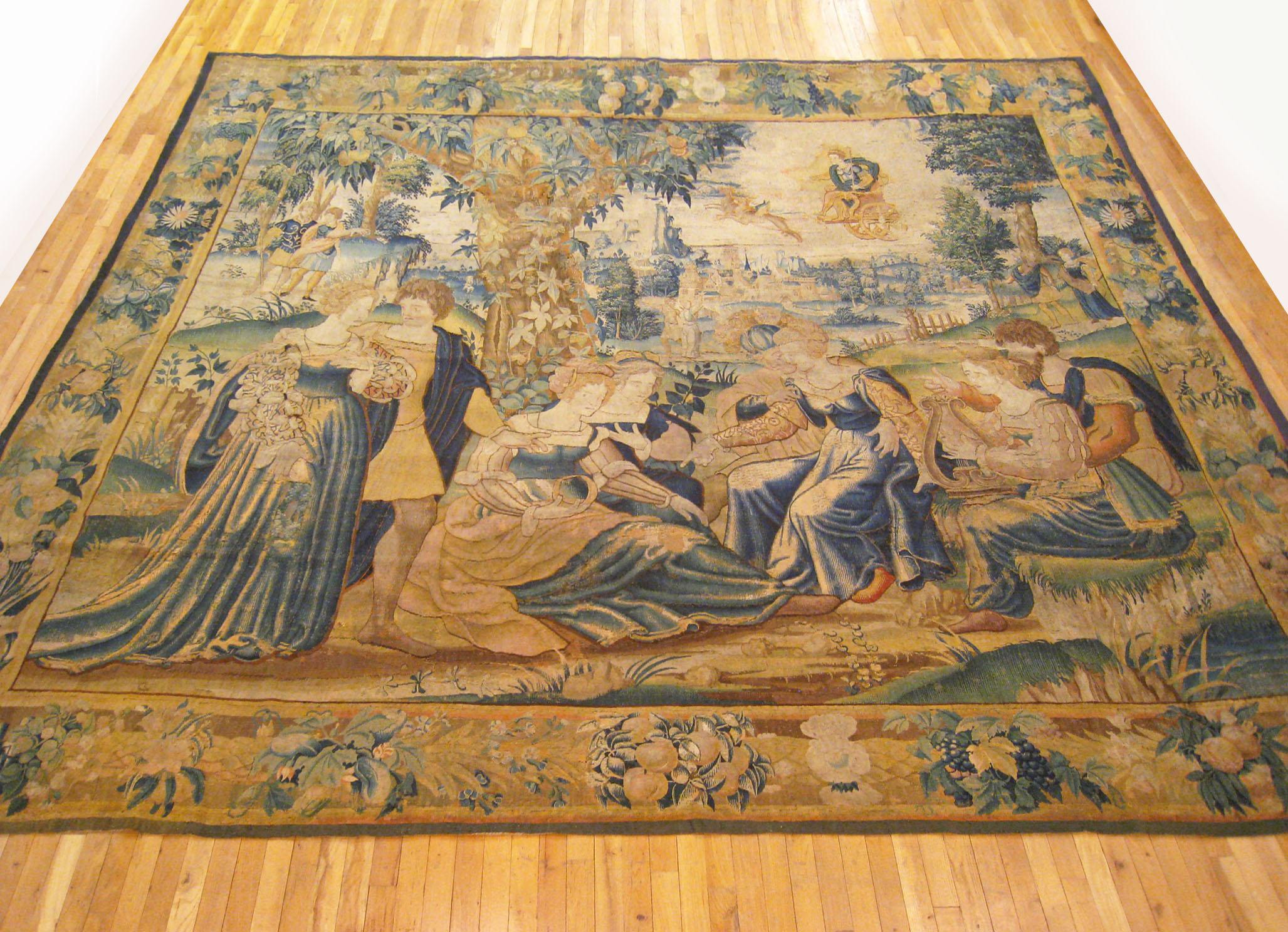 An antique 18th century Flemish mythological tapestry, size 11'0 H x 12'6 W. This period European tapestry depicts the Greek God Apollo, who is the deity of the arts, poetry, crops, and herds, and also presided over religious and civil law. Apollo