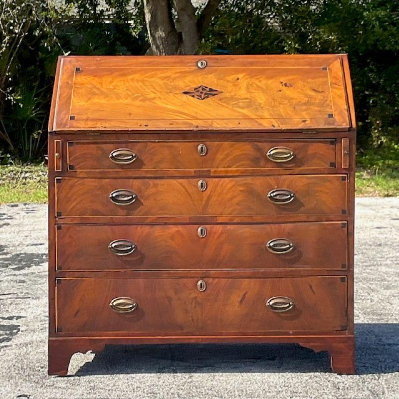 A fabulous vintage 18th century desk. A chic Flame Mahogany drop down desk. Incredible wood grain detail with chic inlay detail. Green felt writing surface and lots of great interior drawers and slots to keep you organized. Acquired from a Palm