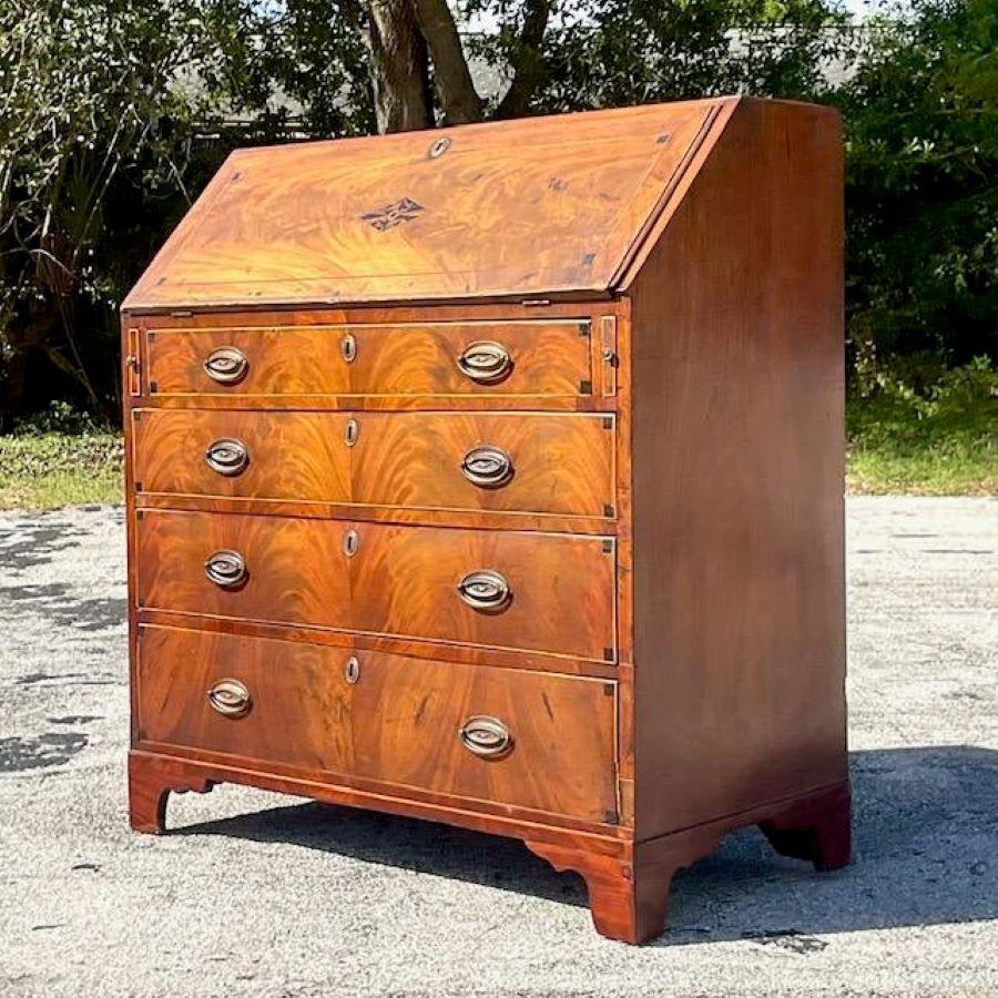 A fabulous vintage 18th century desk. A chic Flame Mahogany drop down desk. Incredible wood grain detail with chic inlay detail. Green felt writing surface and lots of great interior drawers and slots to keep you organized. Acquired from a Palm