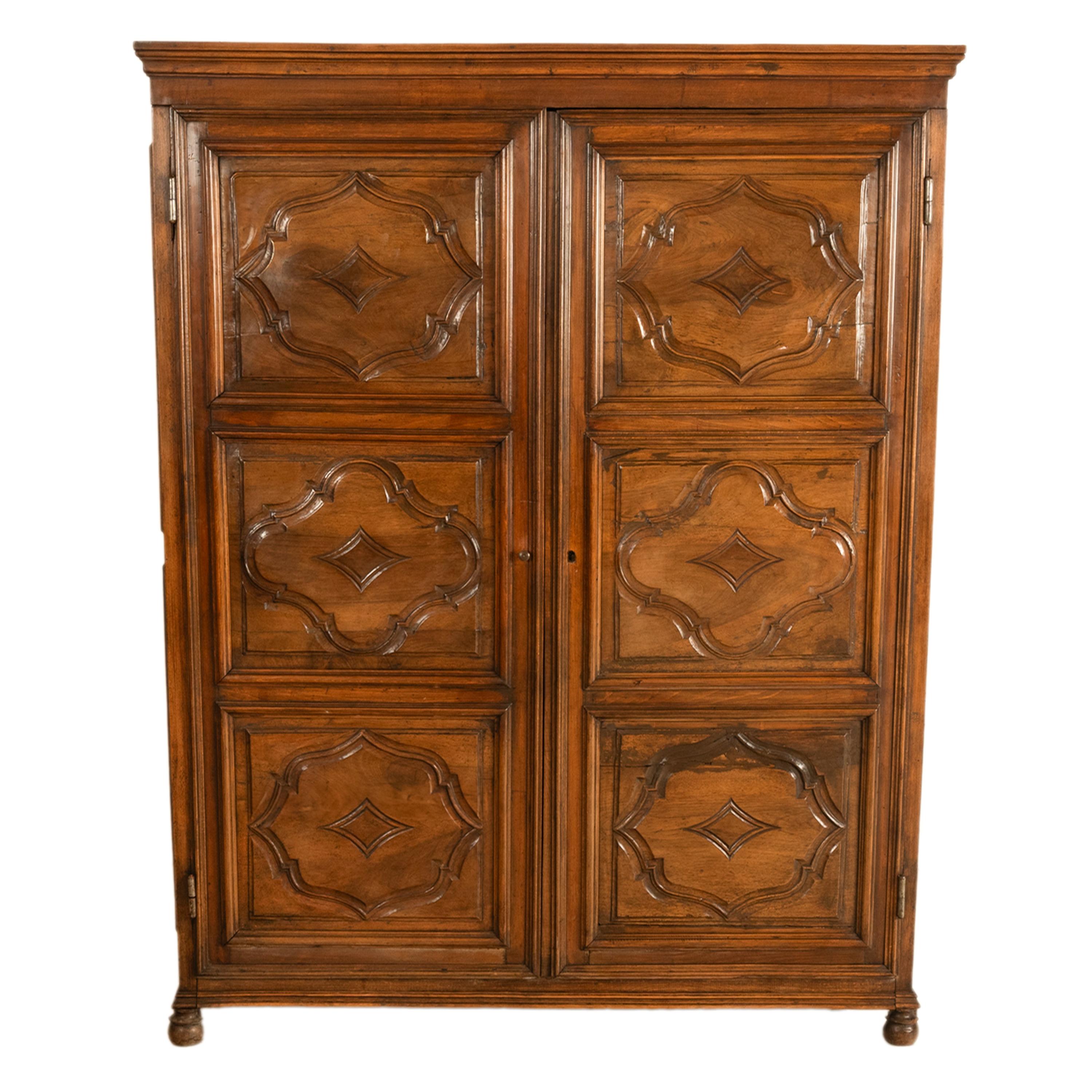 A good antique French Louis XIII style carved walnut bonnetiere armoire circa 1780.
The bonnetiere of unusual diminutive form, having a simple ogee shaped crown with twin doors below, each door is carved with three shaped panels. The doors enclose