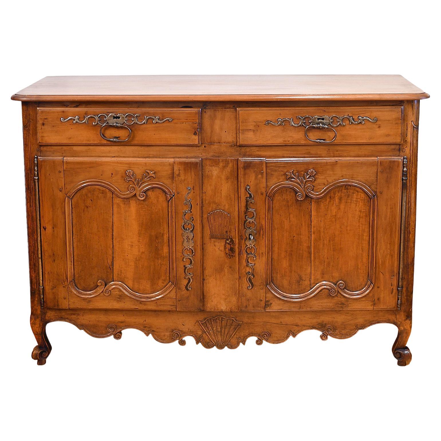 A beautiful 18th century French buffet/ sideboard in cherry wood with rounded bevel-edged, rectangular top resting on a base with two drawers over two cabinet doors. This graceful buffet showcases the stylistic features made popular during the long