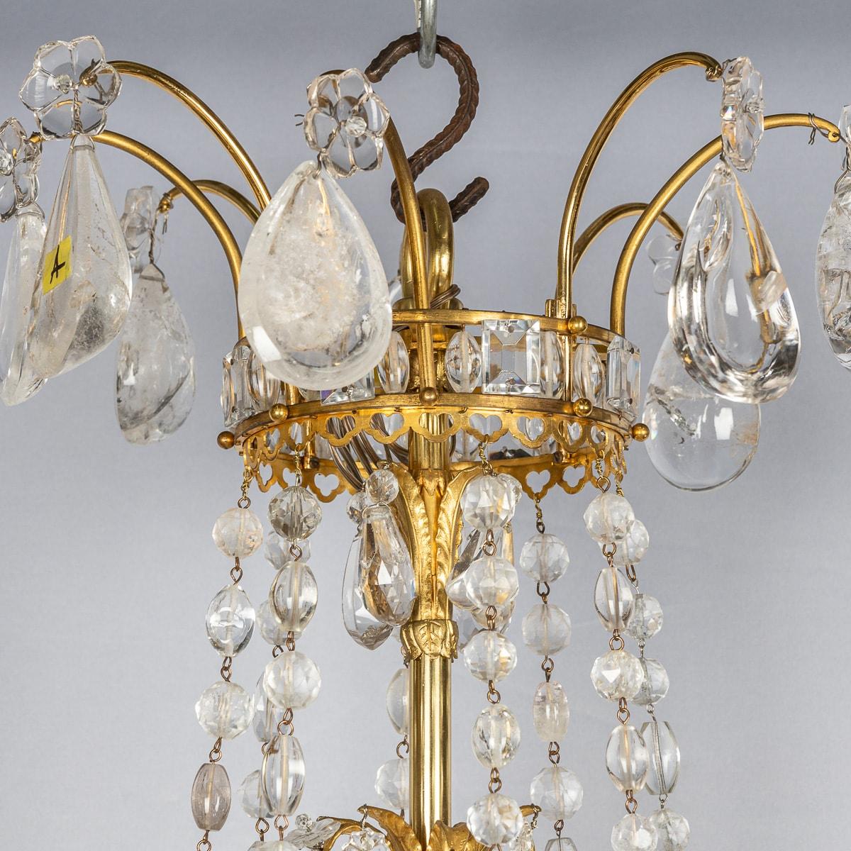 Antique 19th Century French Impressive ormolu bronze and cut rock crystal chandelier. This chandelier is particularly large and magnificent, featuring finely detailed hand cut crystal ornaments shaped like droplets. This chandelier has been