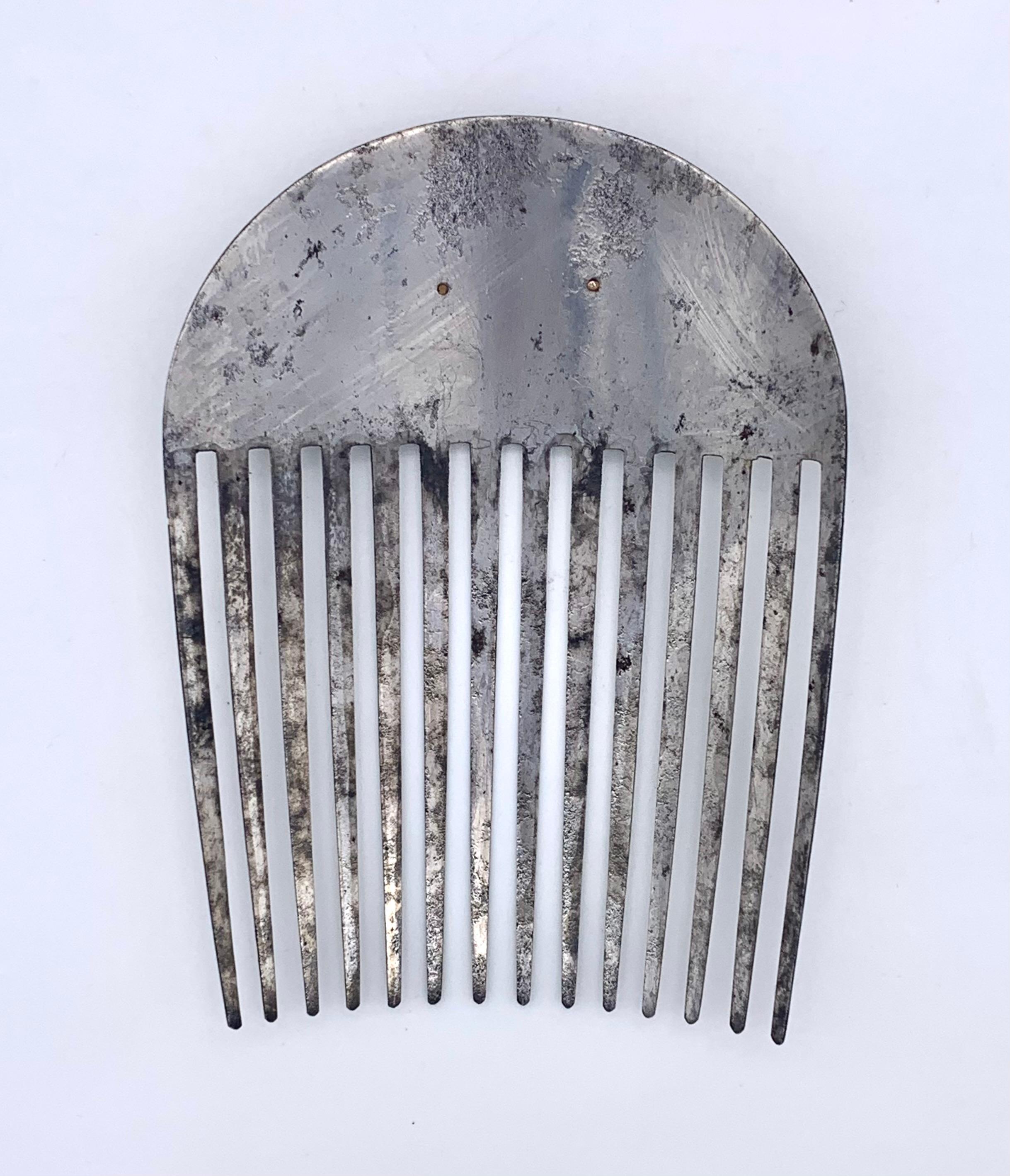 This rare hair comb was cut out of a plate of polished steel during    the period of the French Revolution. The comb has been crafted in a very reduced design, fitting for the taste of the period. It is embellished with an oval two layered two