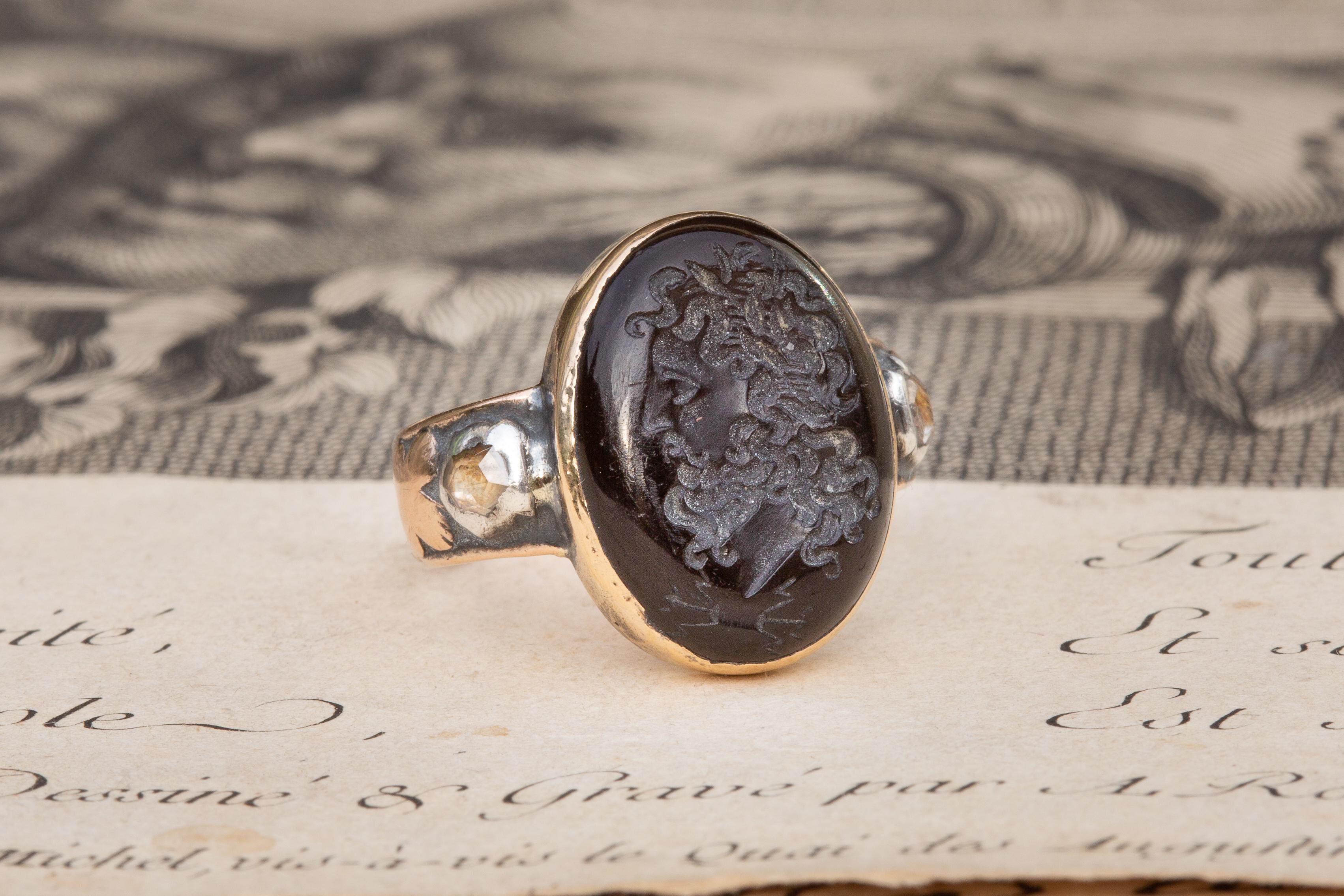 Rare Antique Late 18th Century Garnet Intaglio Signet Ring with Rose Cut Diamonds

This fantastic signet ring dates to around 1780 and was made in Paris. A closed-back and bezel set 3.7ct garnet cabochon gemstone is intricately engraved to depict