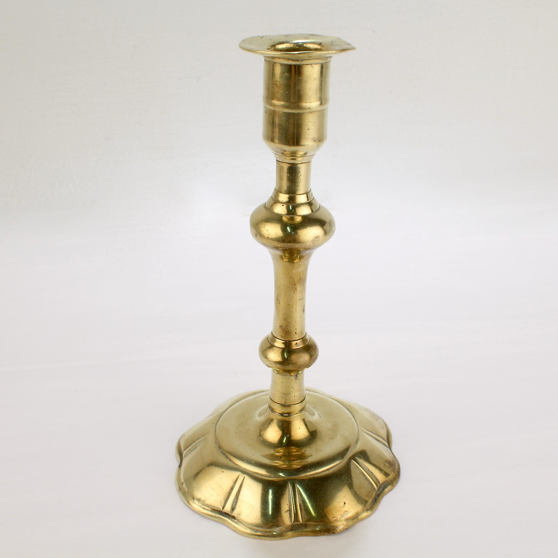 A fine antique English candlestick.

With a 8 lobed petal base, a turned shaft, and an integral bobeche. 

Simply a fine period candlestick!

Date:
Mid-18th century

Overall condition:
It is in overall far, as-pictured, used estate