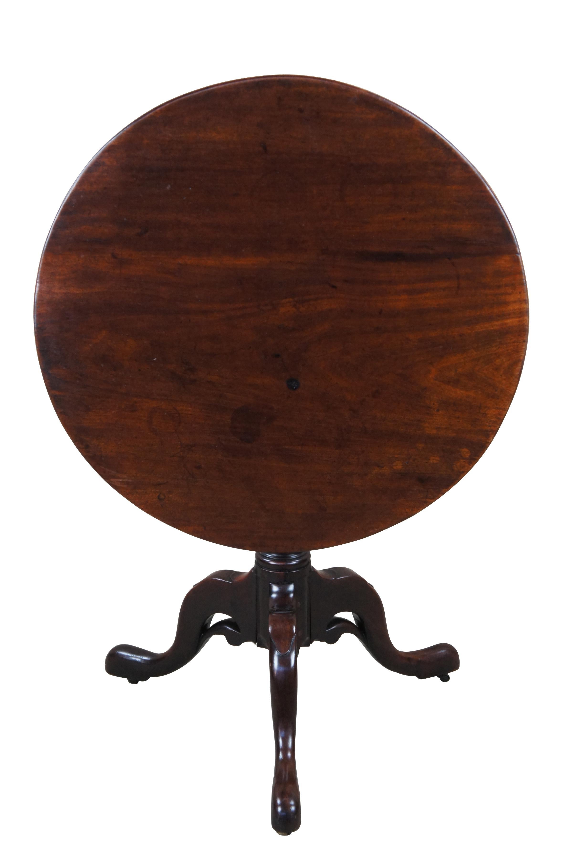 Rare English antique 18th century Georgian tilt top birdcage pedestal tea table.  Made of mahogany featuring round tilt top supported by tri leg base with unique downswept pierced accent, queen anne slipper feet and petite casters. 
