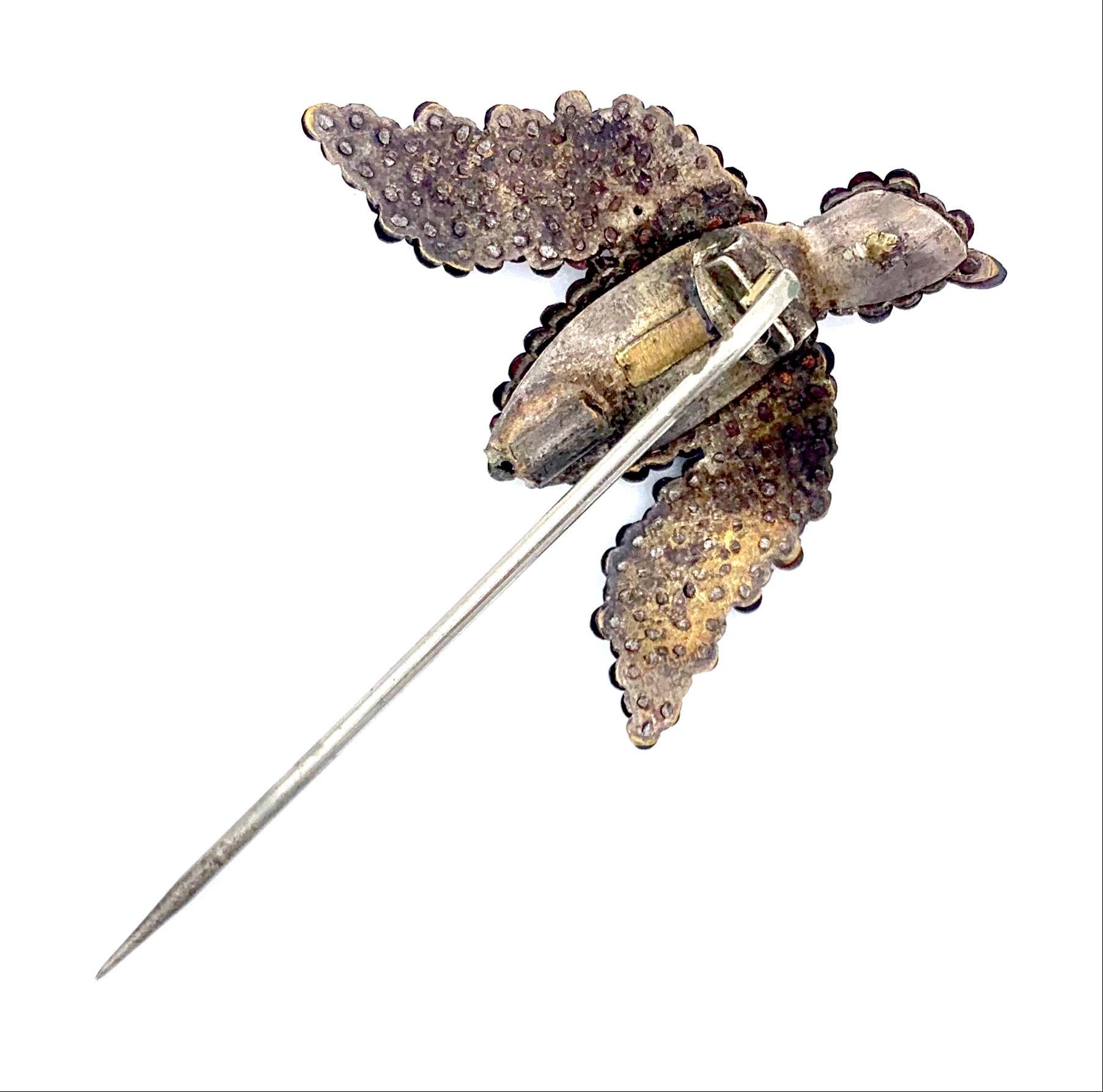 This charming pin with a bird was handcrafted in the 2nd half of the 18th century.  It is made from steel. The bird is made out of cut steel, its entire surface is covered with tiny facetted steel nails riveted on to a metal plate from behind. Cut