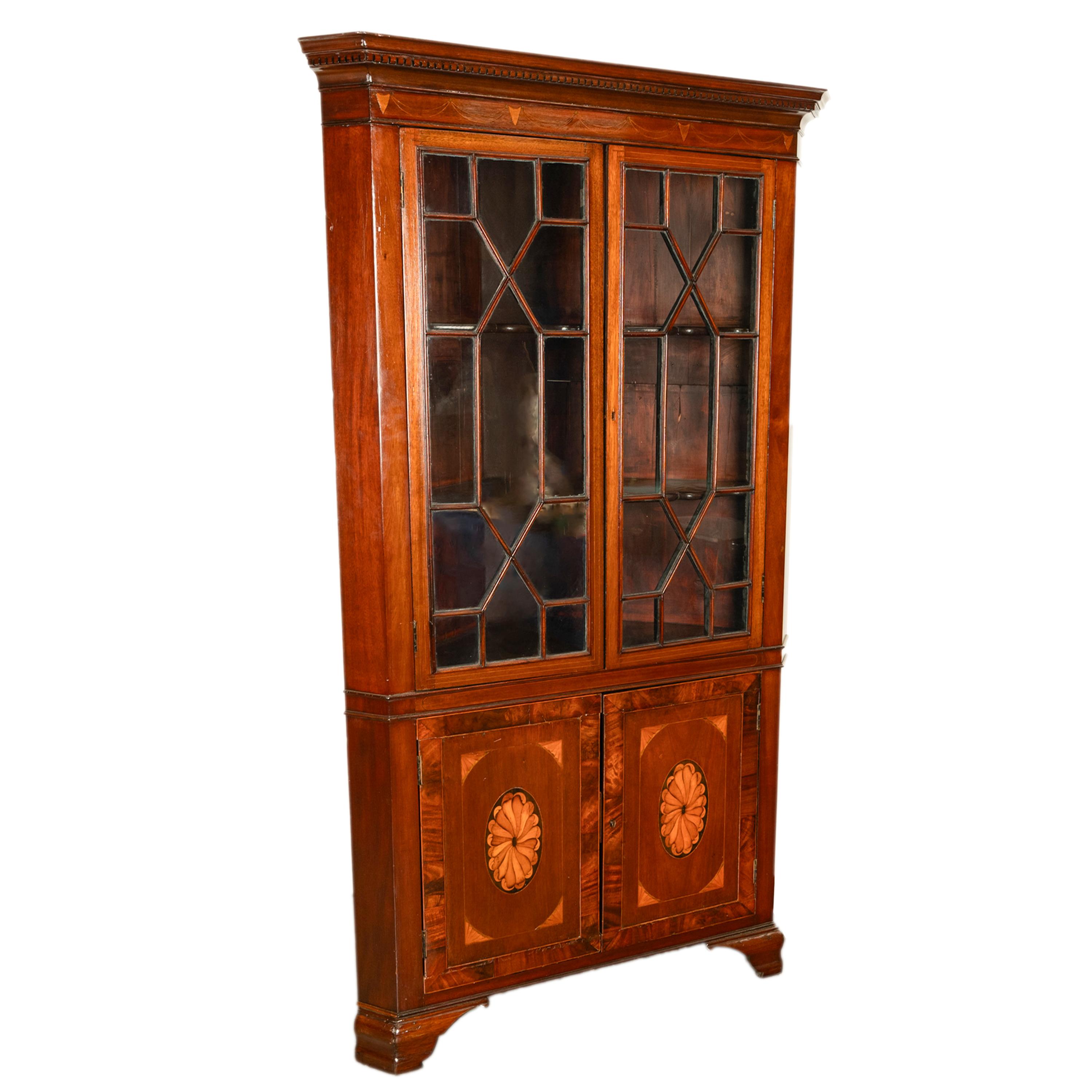 A fine antique freestanding inlaid Georgian mahogany corner cabinet, circa 1790.
The cabinet is made from flamed Cuban mahogany & having a dentil cornice to the top, below is an inlaid garland of swags & shields and the top part of the cabinet with