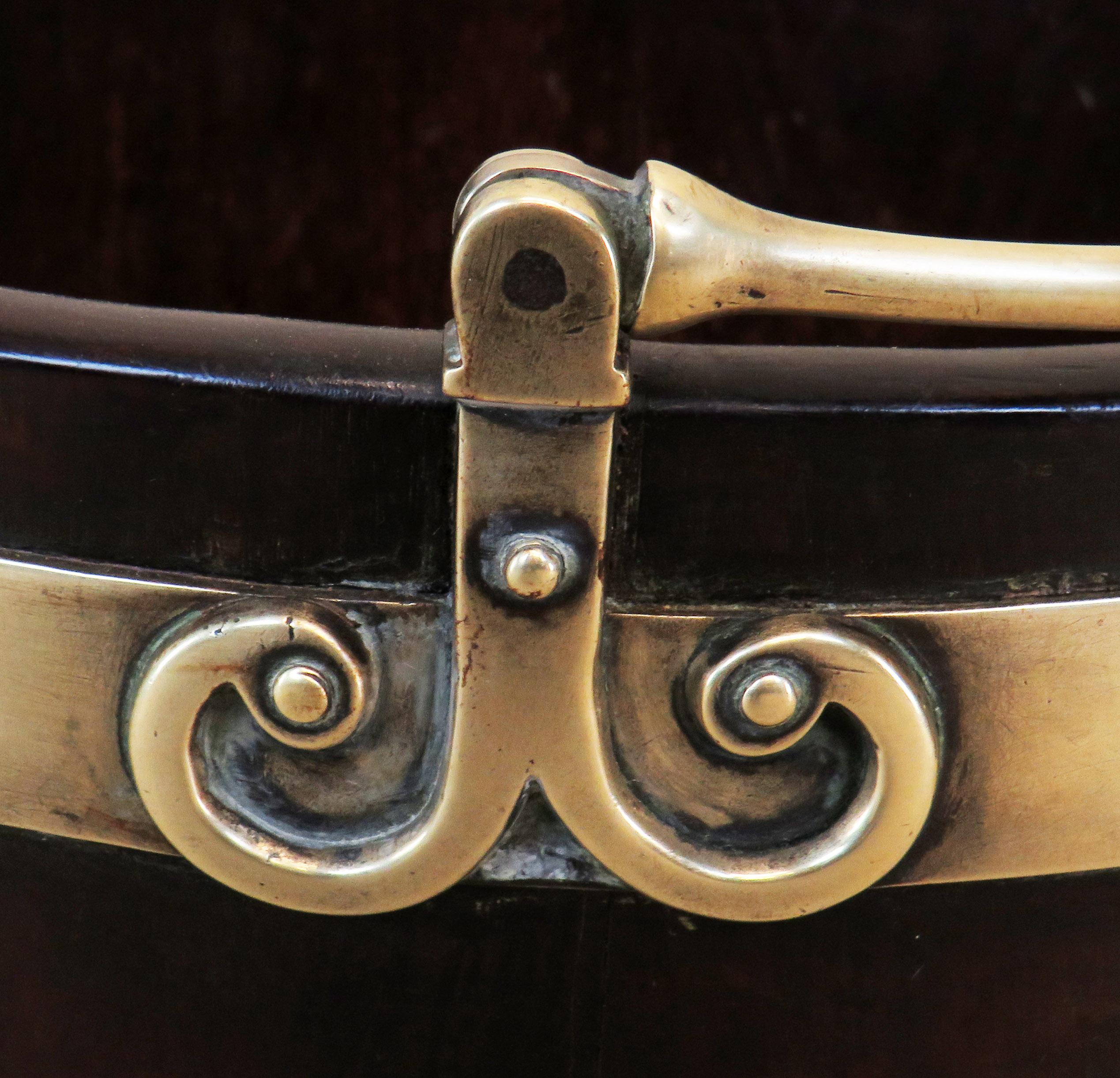 A very good quality late 18th century mahogany
And brass bound plate bucket having original
Pivoting brass handle.

(This bucket would originally have been made to stand
in the dining room and house a pile of plates, hence 
hole cut out of one