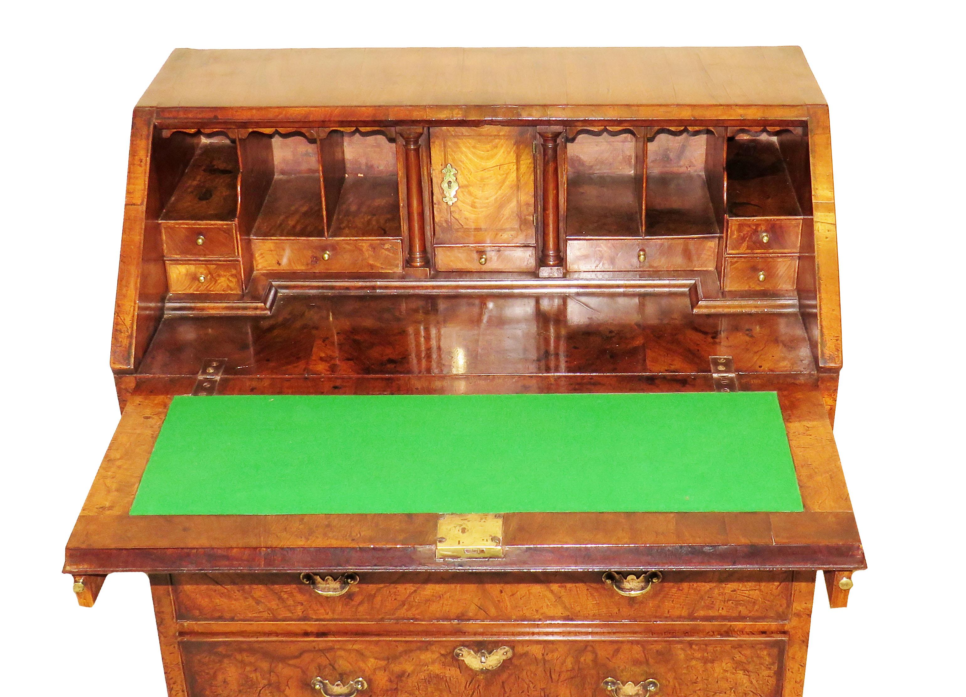A delightful early George II period walnut bureau of superb
color and patination having superbly figured fall front enclosing
well fitted interior above four long drawers with replacement brass
handles raised on original shaped bracket