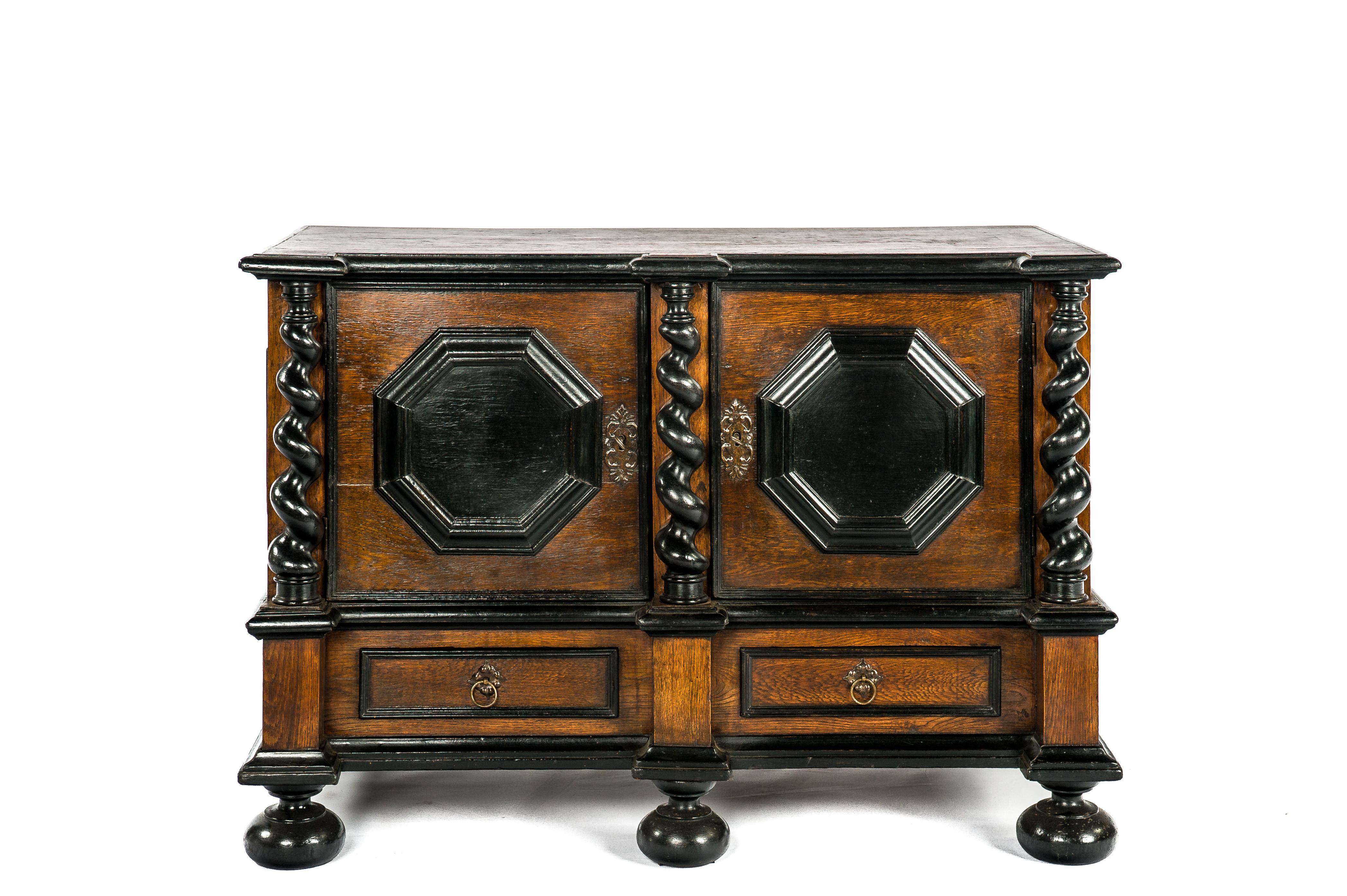 A very handsome Baroque-style cabinet was made in Germany at the end of the 18th century. It has a detachable base with a drawer over bun feet. Above sits a compartment with two paneled doors flanked by barely twisted slightly tapered columns. The