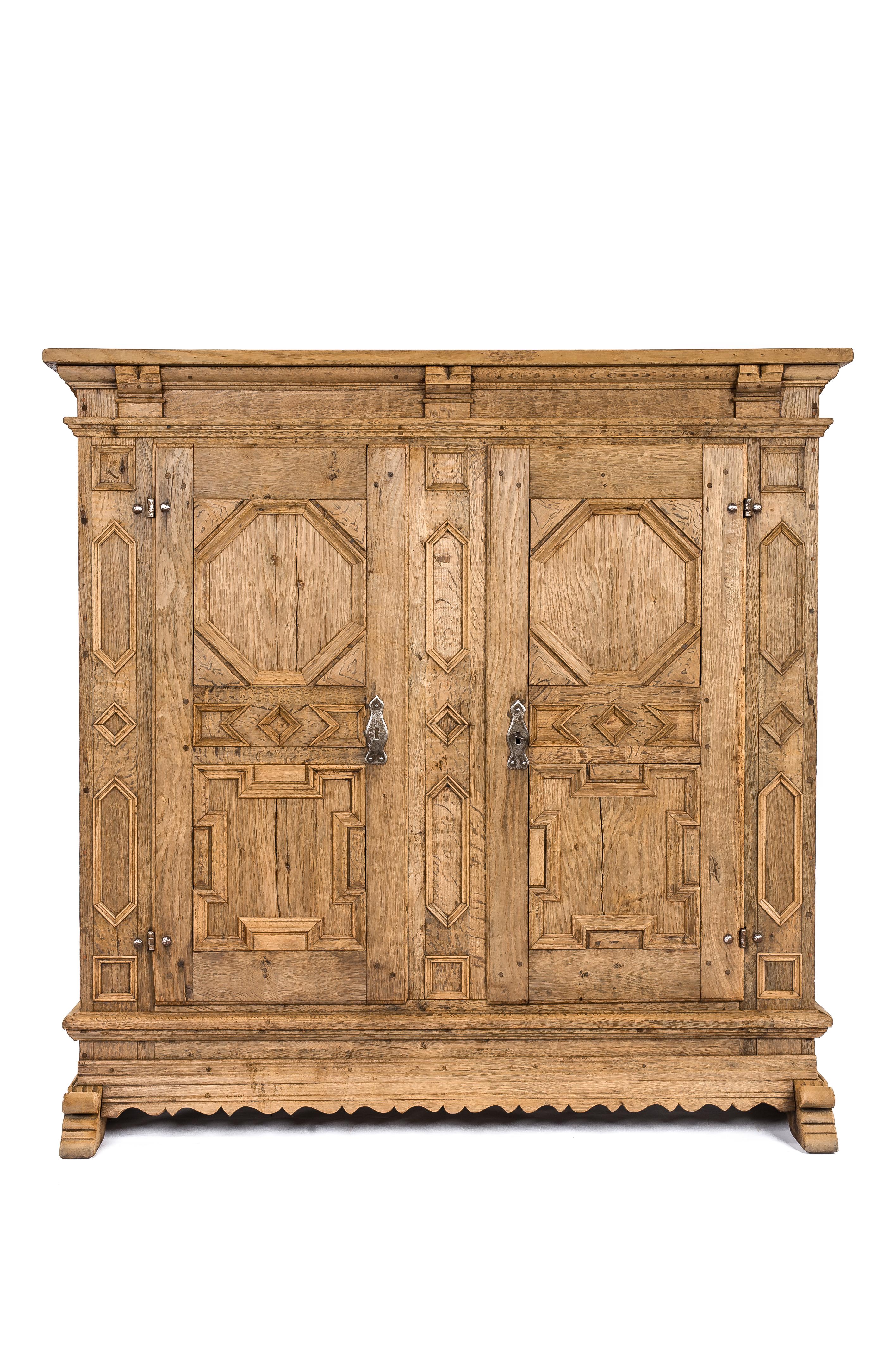 A beautiful 18th-century German baroque armoire or cabinet with two doors. It was made from solid European summer oak to last for generations, it features an intricate geometric design and spacious storage inside. It originates in the region