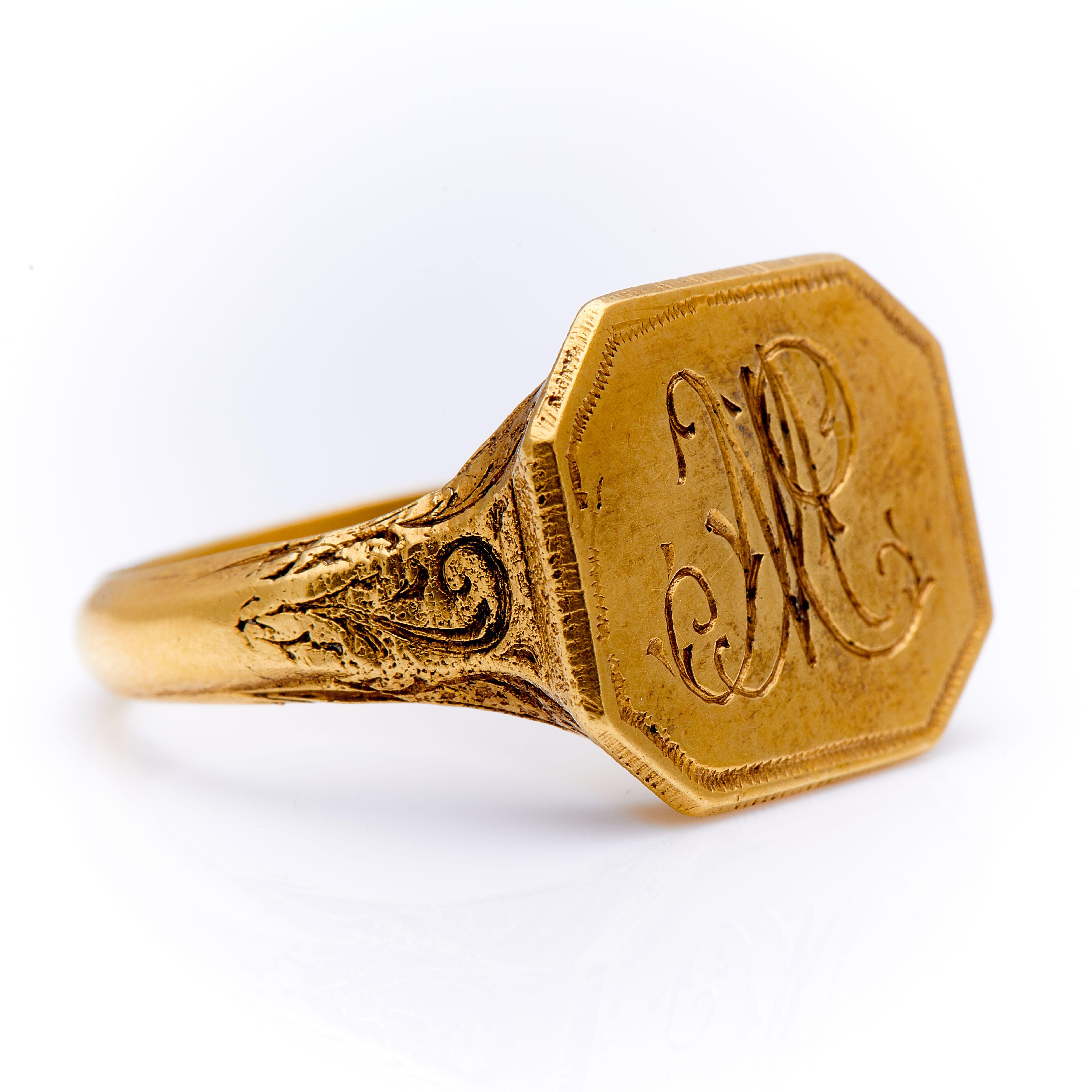 18th century, gold signet ring from England, circa 1790. An impressive heavy gold signet ring, the central square plaque is engraved with a elaborate letter ‘M’ and framed by incised beaded edging. The ornate engraved decoration continues underneath