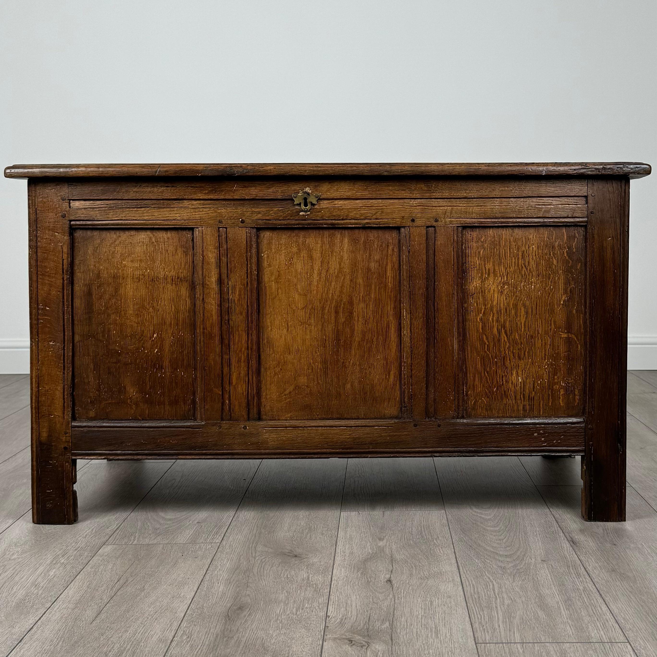 Questo splendido scrigno antico del XVIII secolo, realizzato in ricca quercia dorata, è un pezzo notevole che combina funzionalità ed eleganza senza tempo. Poggiato su robuste gambe quadrate, questo forziere offre una base solida e stabile,