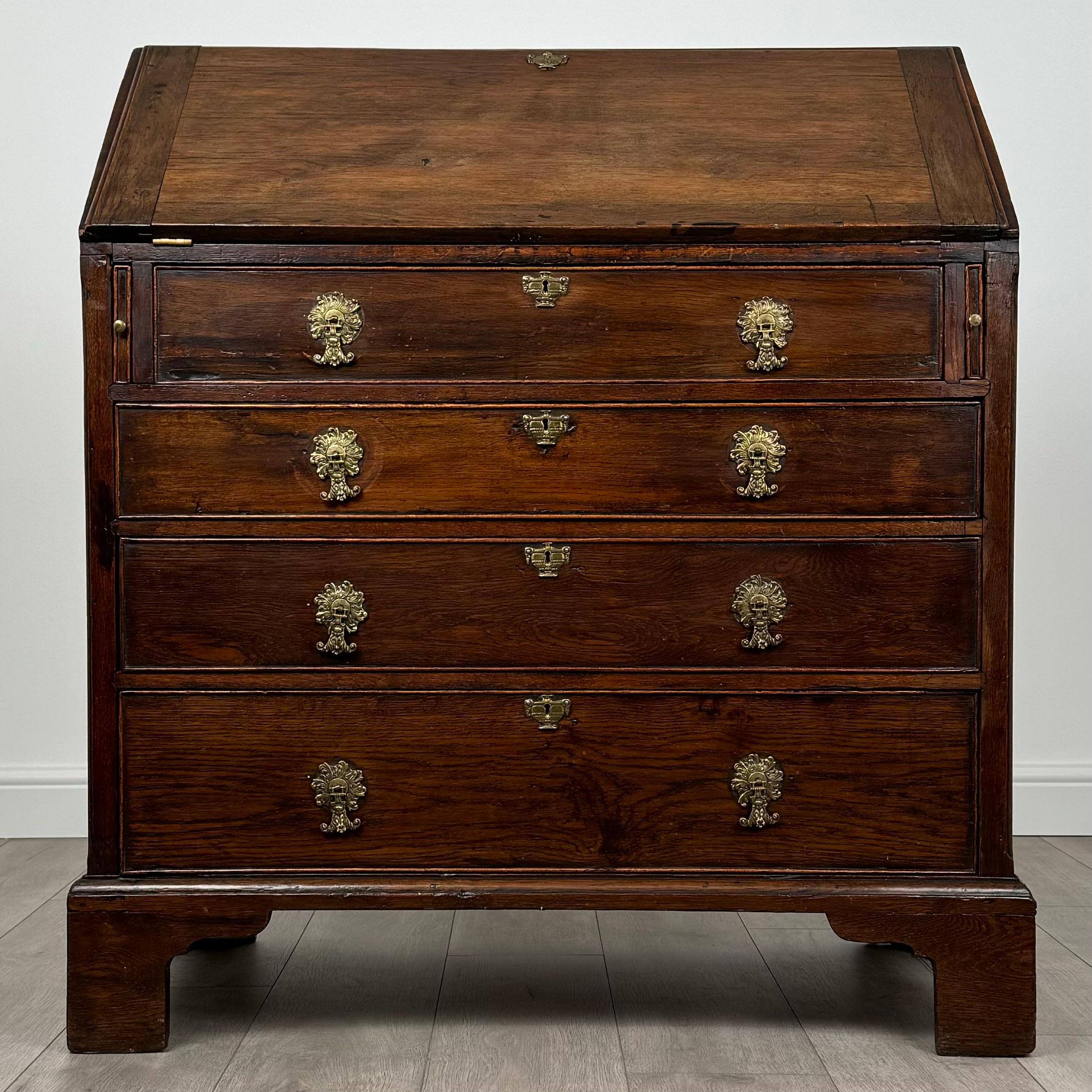 This impressive 18th-century antique oak bureau is a stunning example of classic craftsmanship and elegance. 
Standing on traditional bracket feet, the bureau has a sturdy, balanced presence that highlights its enduring quality. The lower section