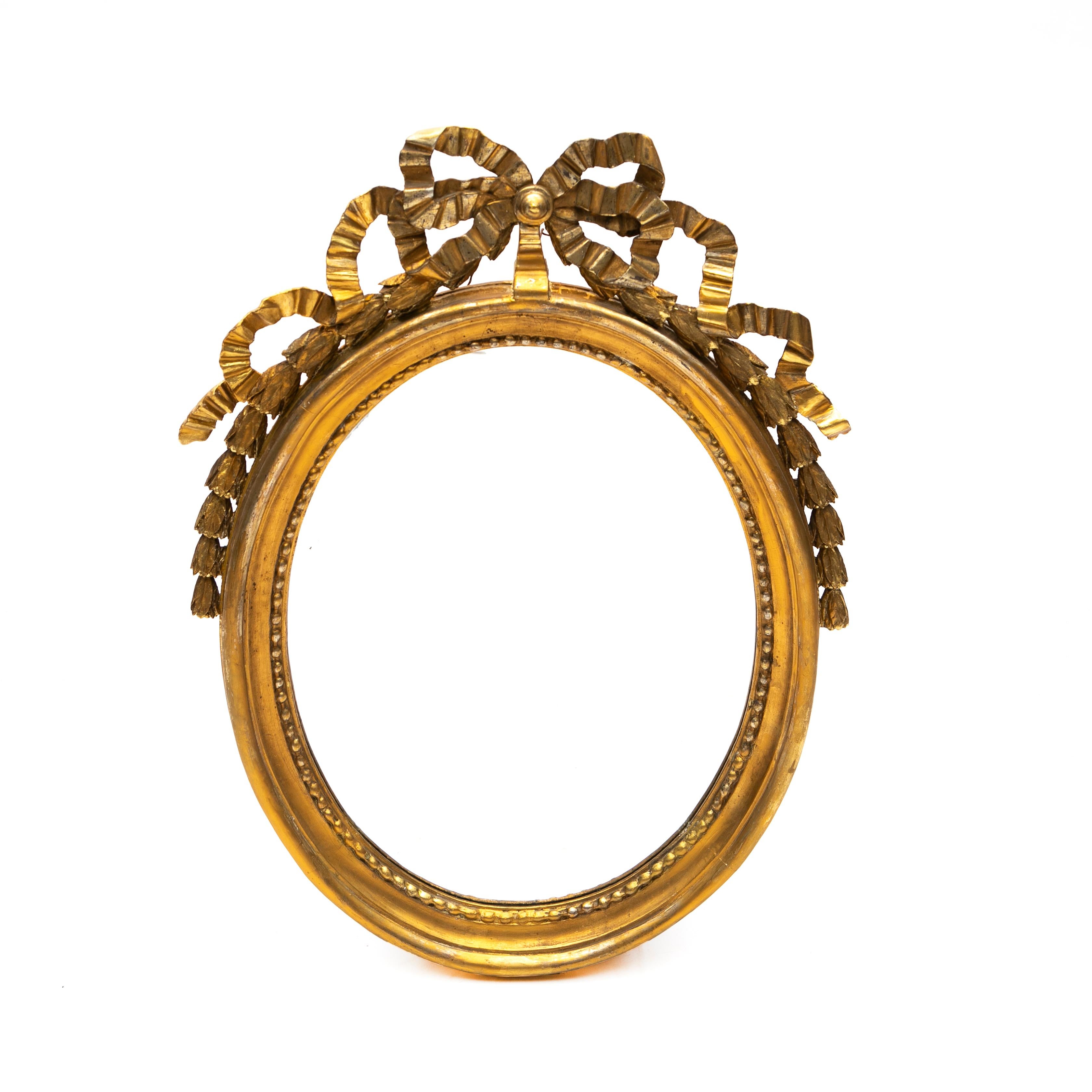 Classic Gustavian or Louis Seize carved giltwood wall mirror.
Features an oval mirror with pearl beading on the interior perimeter, exterior frame decorated with a bow-tied ribbon on top and trailing bellflowers along the sides.

Sweden 1780-1790