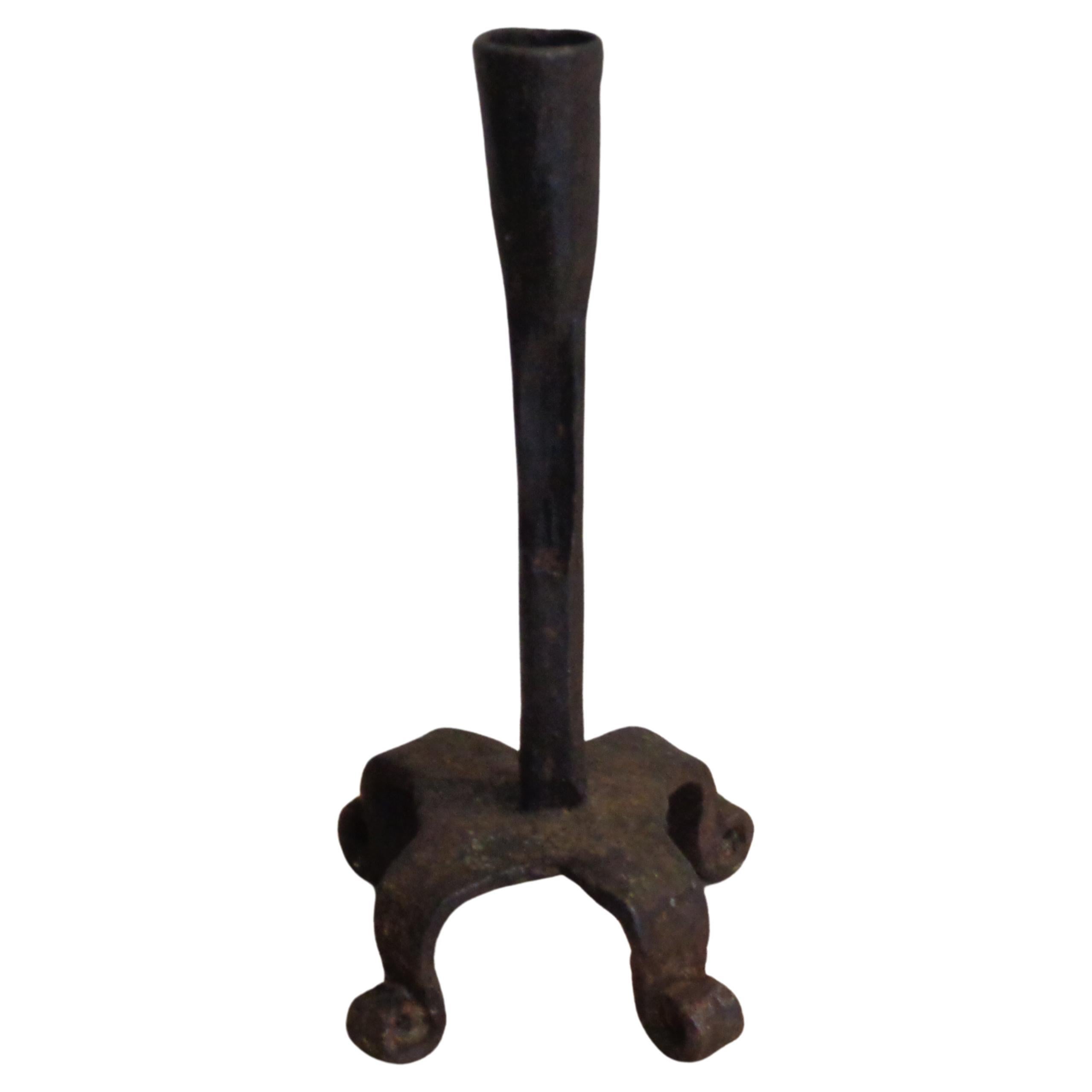 18th century hand forged primitive iron candlestick in nicely aged original old surface. Measures 8 inches high x 4 1/2 inches across curled four footed base. Look at all pictures and read condition report in comment section.