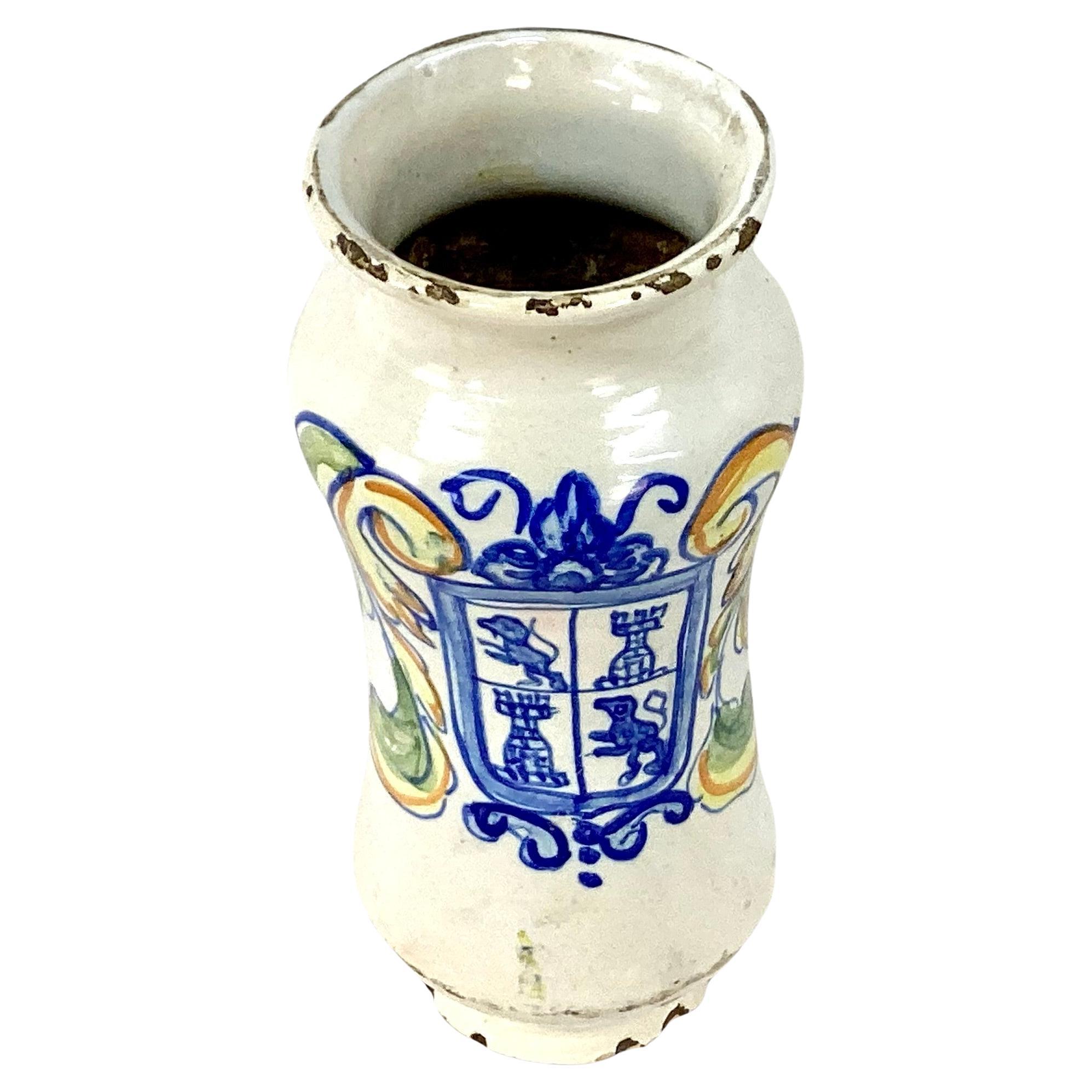 Tall antique 18th century Italian ceramic apothecary jar. Colors of blue, yellow and green on off white background.