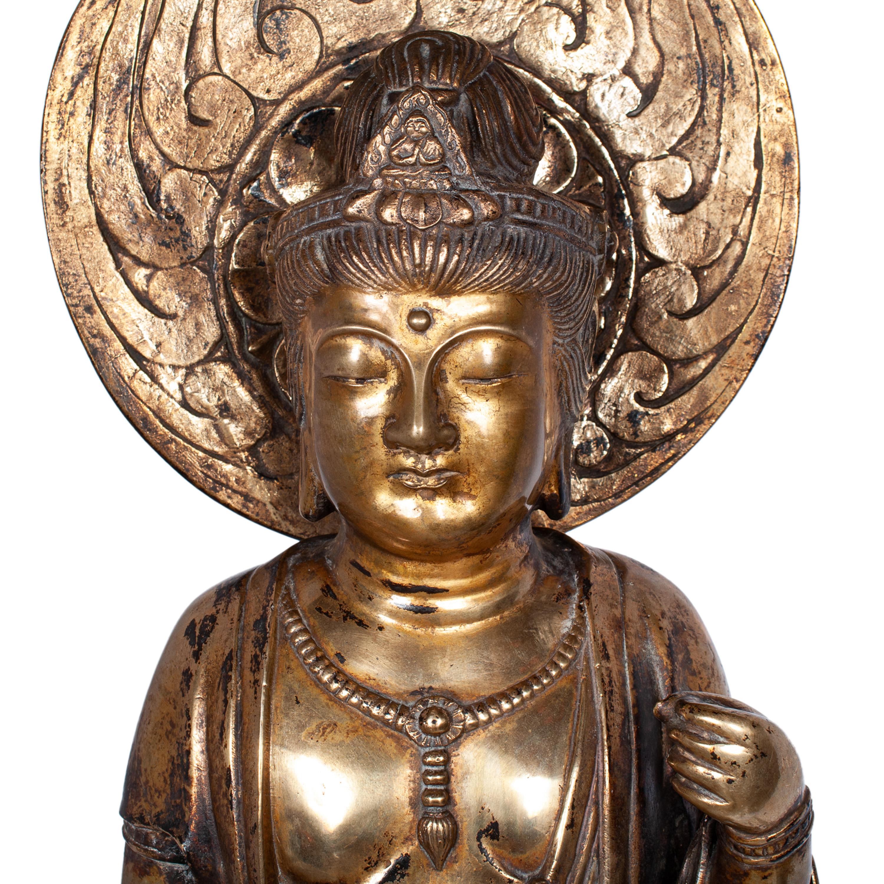 Une belle et rare statue de Kannon en bronze doré du 18e siècle de la période Edo au Japon, vers 1750.

Cette statue en bronze finement coulé et doré représente la bodhisattva japonaise de la Miséricorde élevée sur un double lotus, la main droite