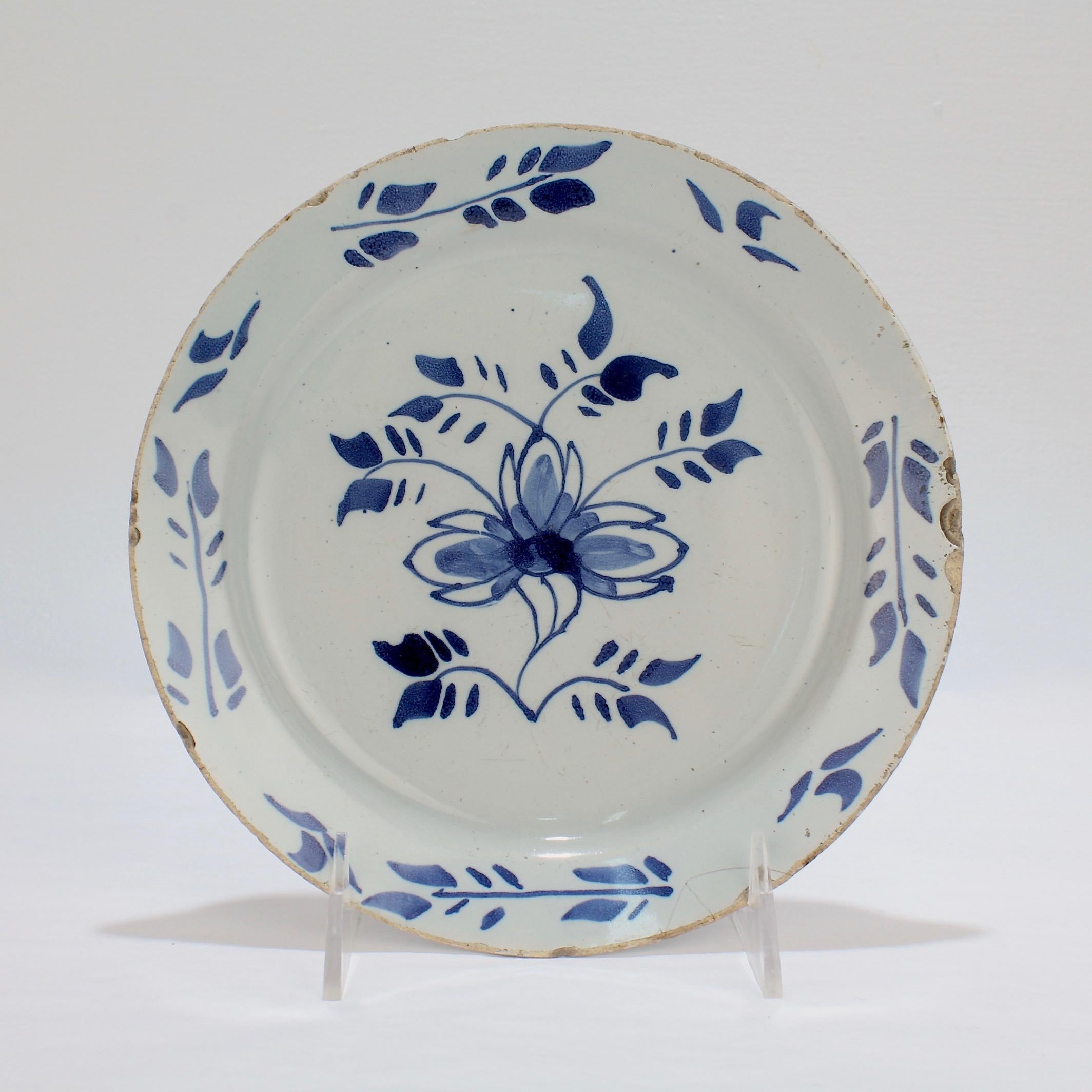 A good, early London delft pancake plate.

With a stylized flower to the center and leaf sprays decorating the border.

Measures: Diameter ca. 7 3/4 in.

Items purchased from this dealer must delight you. Purchases may be returned for any reason for