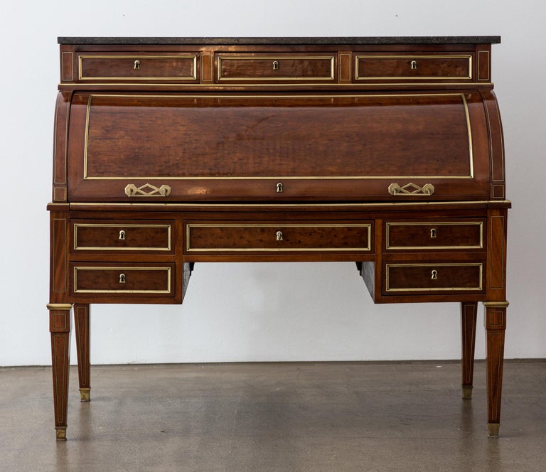 Very elegant freestanding antique French cylinder writing desk veneered with polished Acajou moucheté (fly mahogany) from the Louis XVI period.
Beneath the roll top are five drawers in two registers. Inside the bureau is a removable leather-covered
