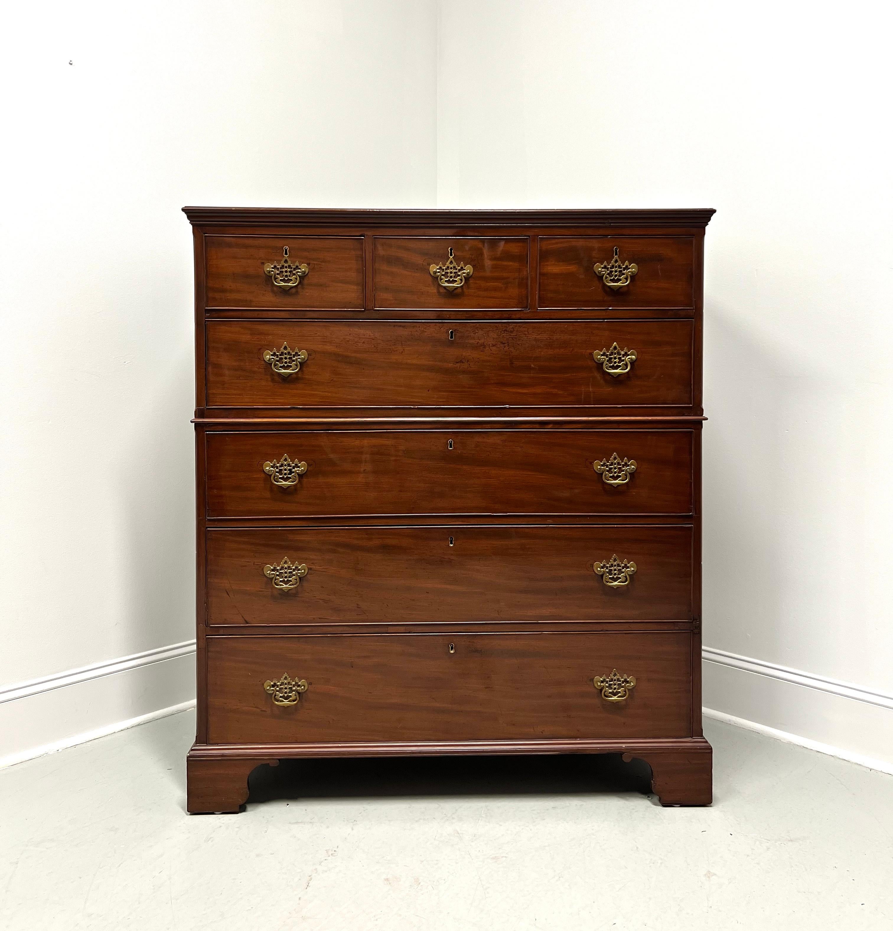 An antique 18th Century extra-large chest on chest of drawers in the  Chippendale style, unbranded. Mahogany with bevel edge to the top, later added decorative brass hardware, bevel edge dividing chests, and bracket feet. Features three smaller over