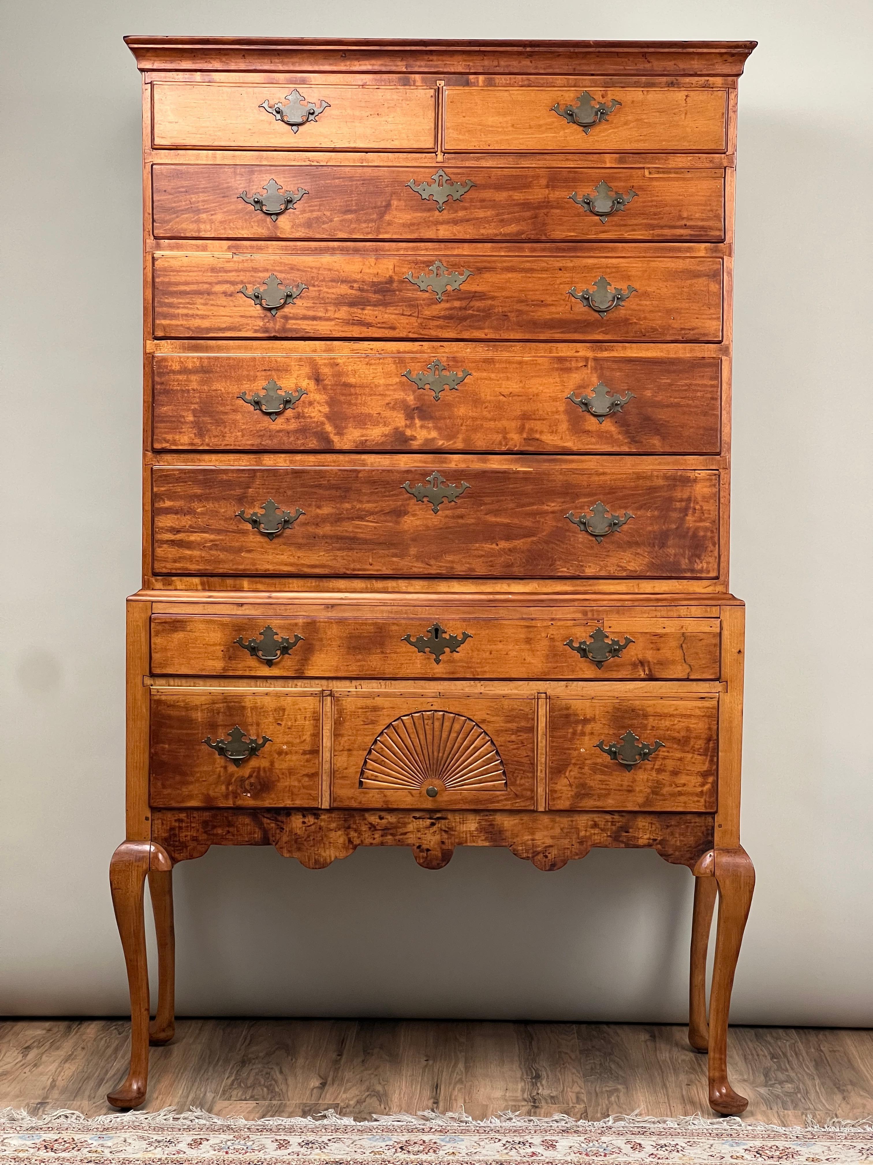 This distinguished 18th-century New Hampshire Queen Anne maple highboy, a testament to early American craftsmanship, showcases the enduring appeal and functionality typical of the period. The highboy features a two-part structure—an upper section