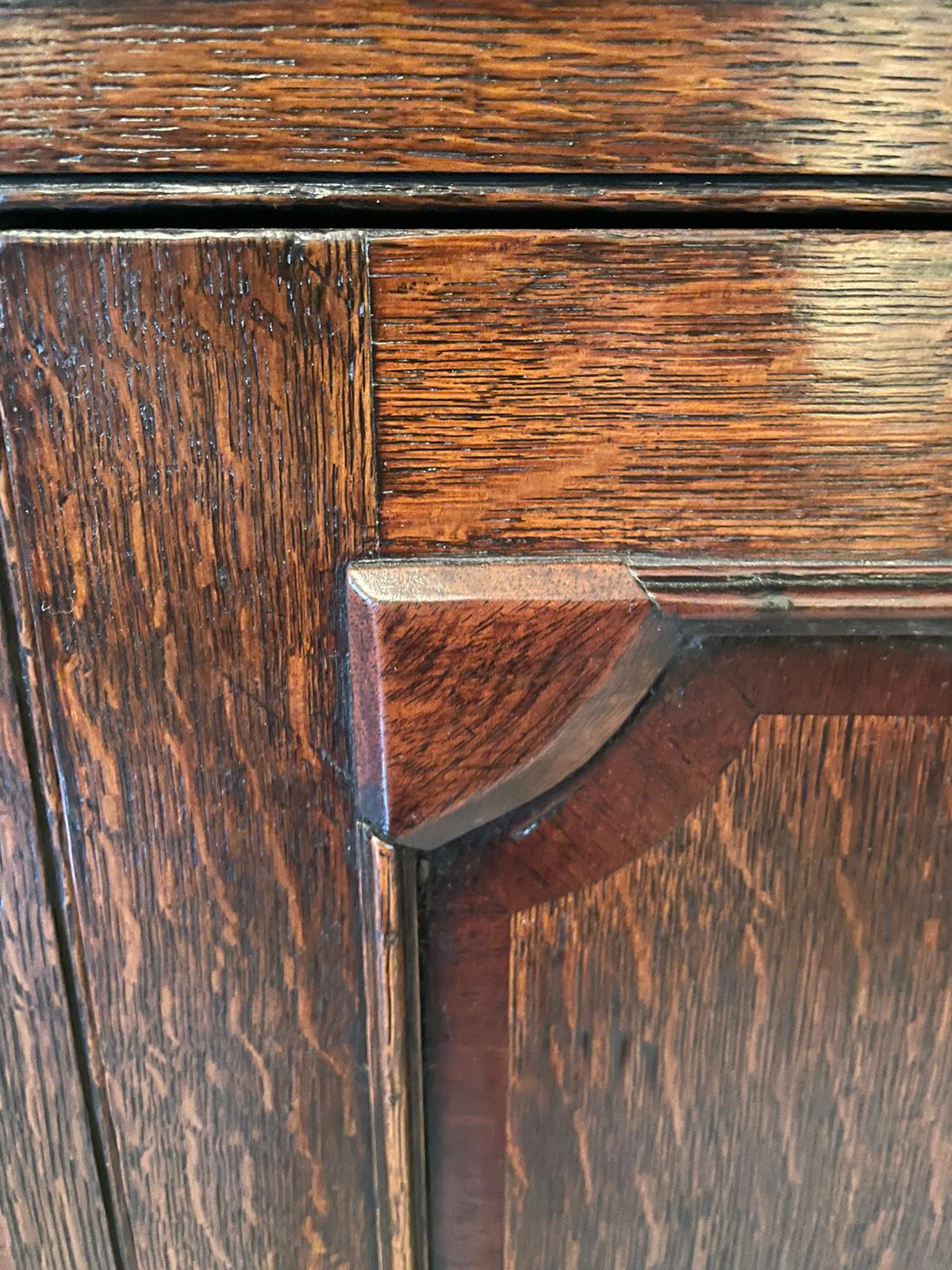 Antico mobile angolare sospeso in rovere del XVIII secolo con una cornice sagomata sopra un congelamento in mogano, un'anta singola sagomata in rovere bordata in mogano che si apre per rivelare tre ripiani originali sagomati, fianchi ribattuti, un