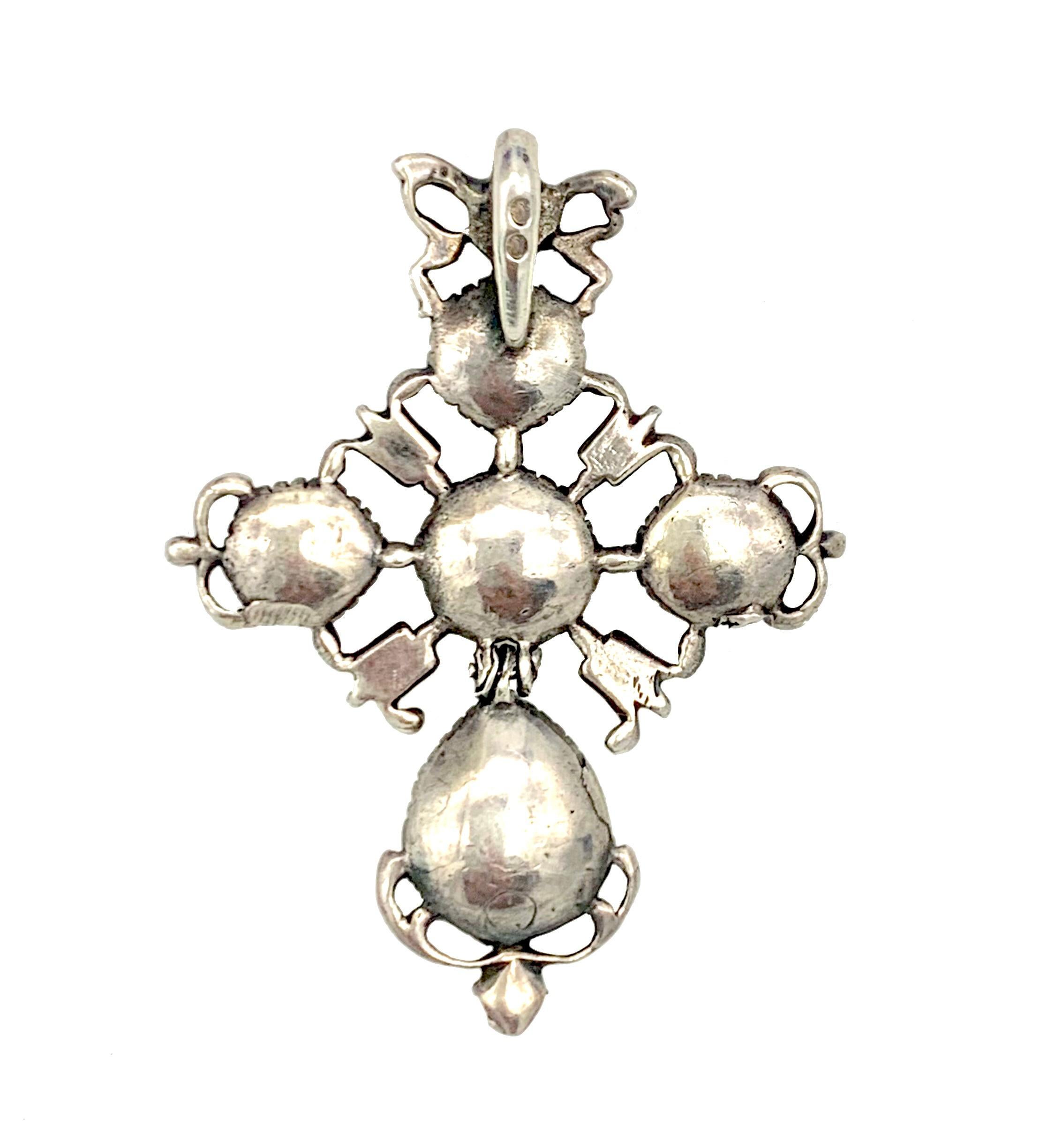 This beautiful and original silver cross was handcrafted in the second half of the 18th century, in the 1770's. The jewel is set with old mine rose diamonds in closed settings. From a bow shaped slide a cross is suspended. The large drop shaped