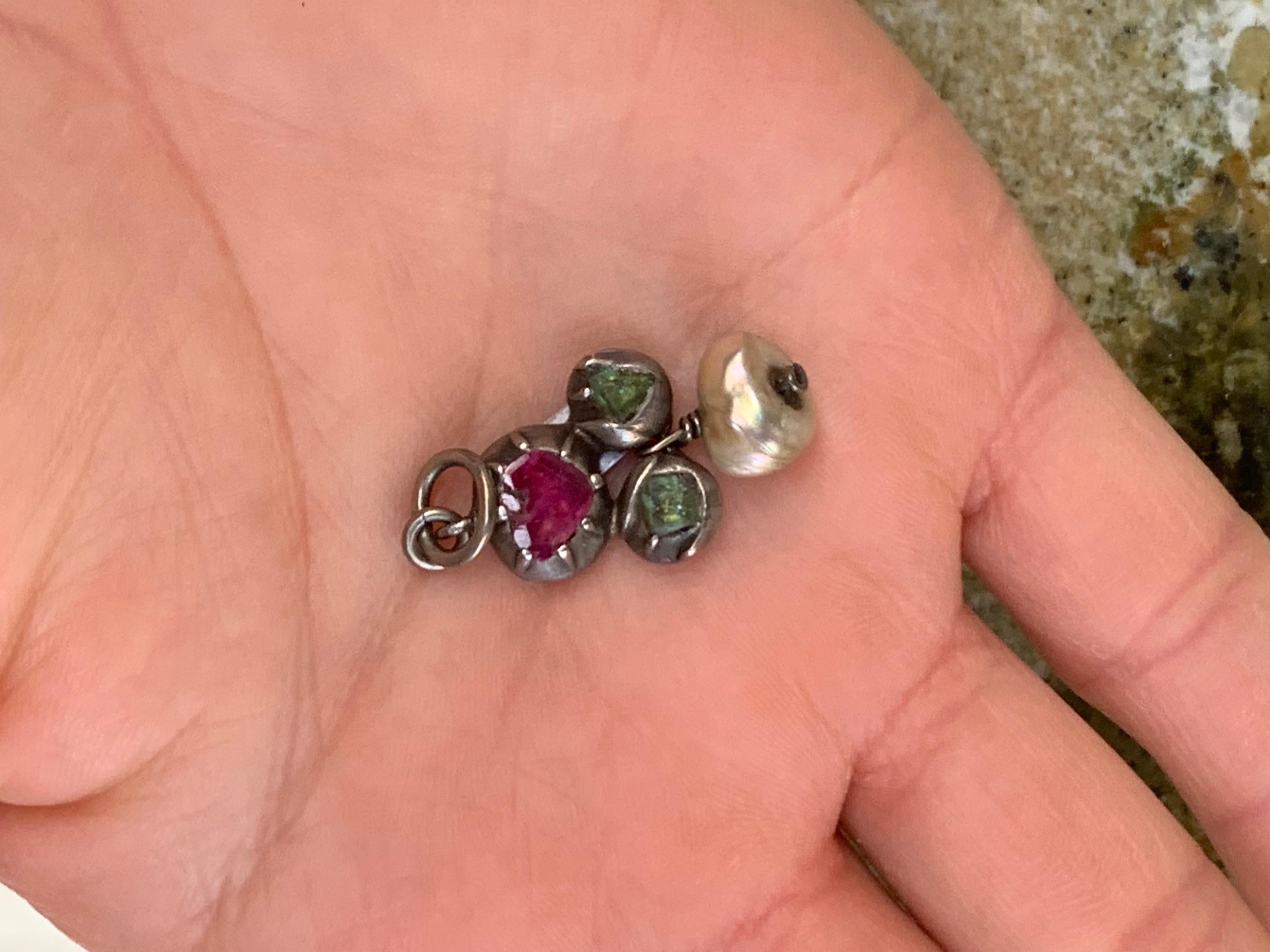 Esta delicada joya es un fragmento de un collar del siglo XVIII.
Otros dos fragmentos iguales más pequeños se han convertido en pendientes colgantes. Las esmeraldas europeas naturales y un rubí natural se han montado en engastes cerrados de plata