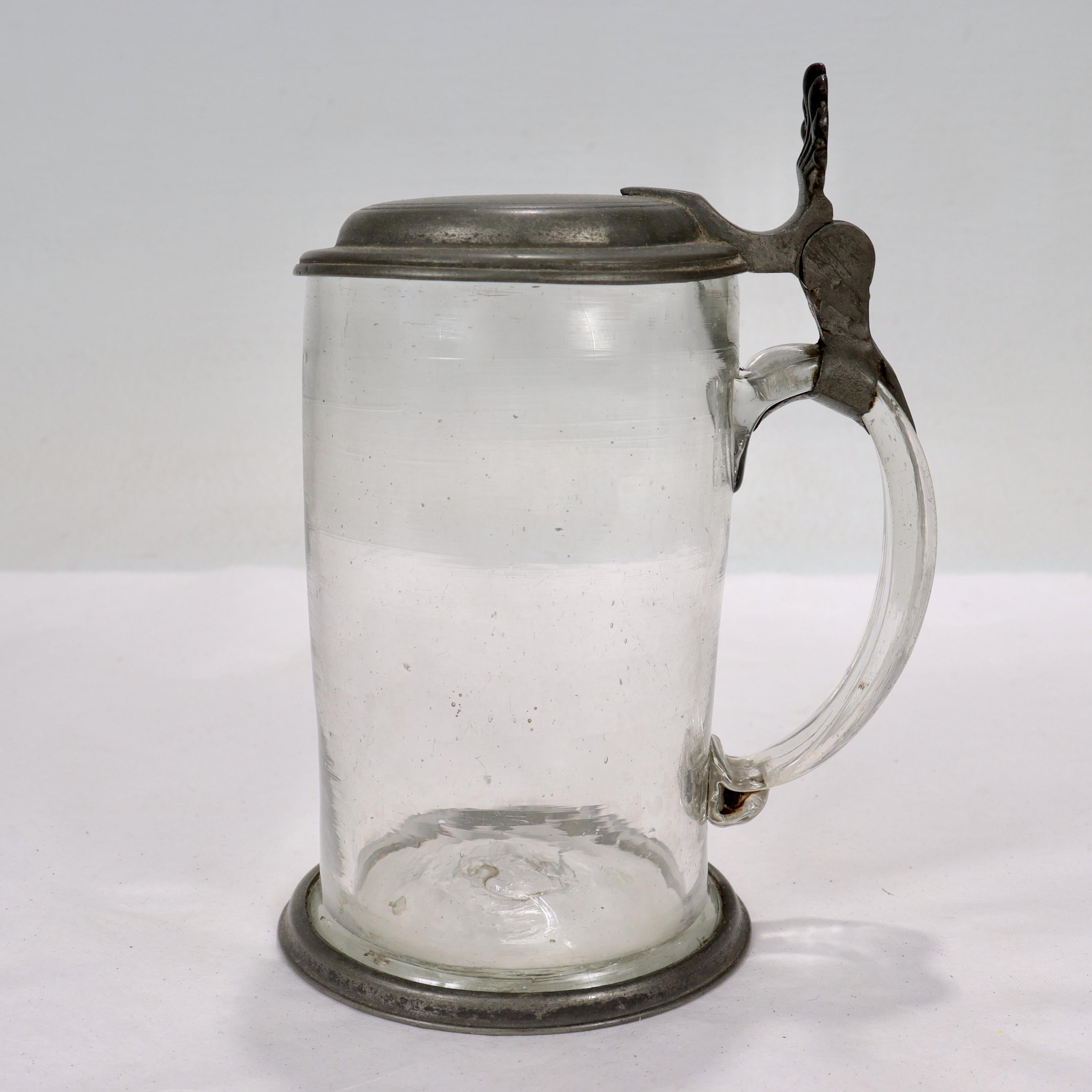 A fine antique 18th century pewter & glass beer stein.

In the form of a glass stein mounted with a pewter lid and pewter foot rim. 

Monogrammed to the lid for 