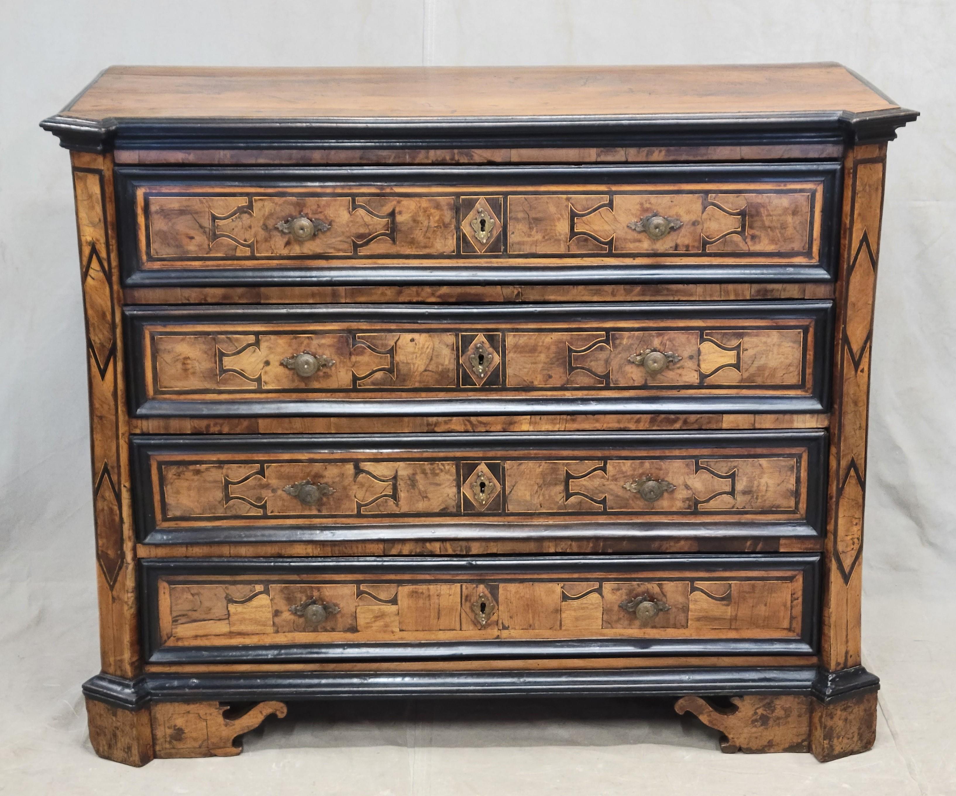 An absolutely stunning antique baroque 18th century Italian, Piedmont region (Northern Italy) chest of drawers / dresser comprised of inlaid olive wood and walnut marquetry. Casework is solid walnut. The curvilinear inlaid designs on the four drawer