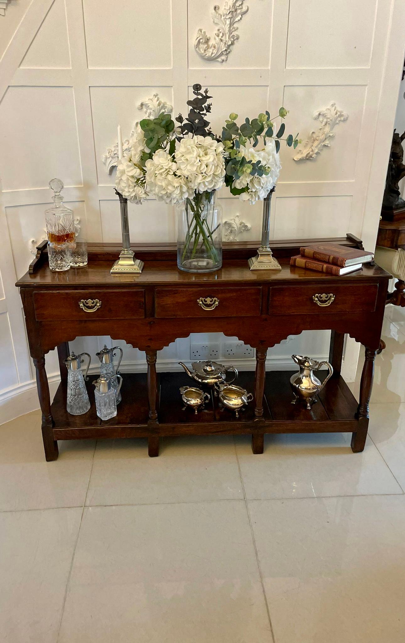 Antique 18th century quality oak pot board dresser base having a quality oak rectangular shaped top with a low gallery above three drawers supported by turned columns and unusual carved supports standing on block feet and united by a oak pot board