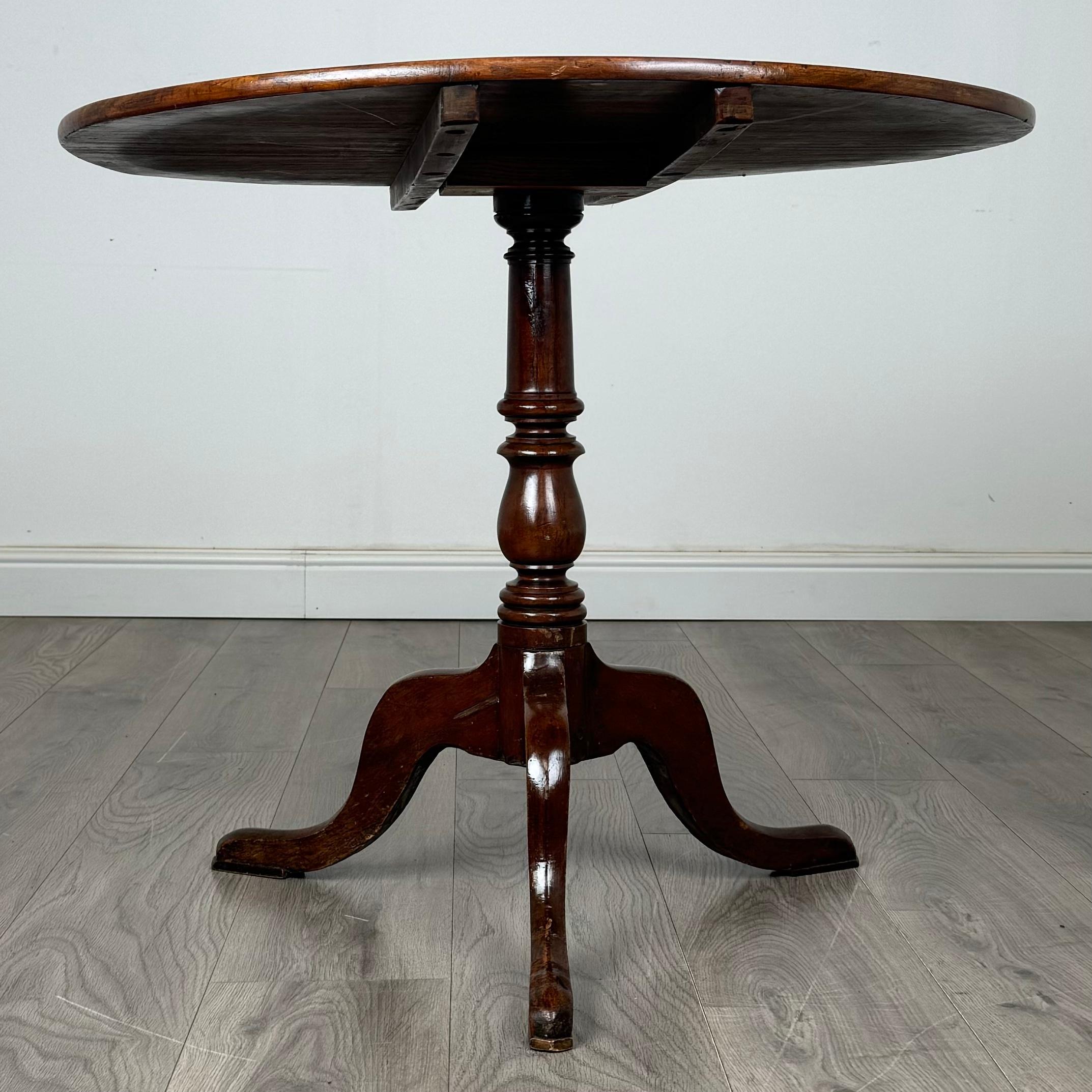 Cette magnifique table à plateau basculant du XVIIIe siècle, fabriquée en acajou, est dotée d'une base tripode classique qui met en valeur son élégante silhouette. La table présente un grain étonnant et une couleur riche qui mettent en valeur la