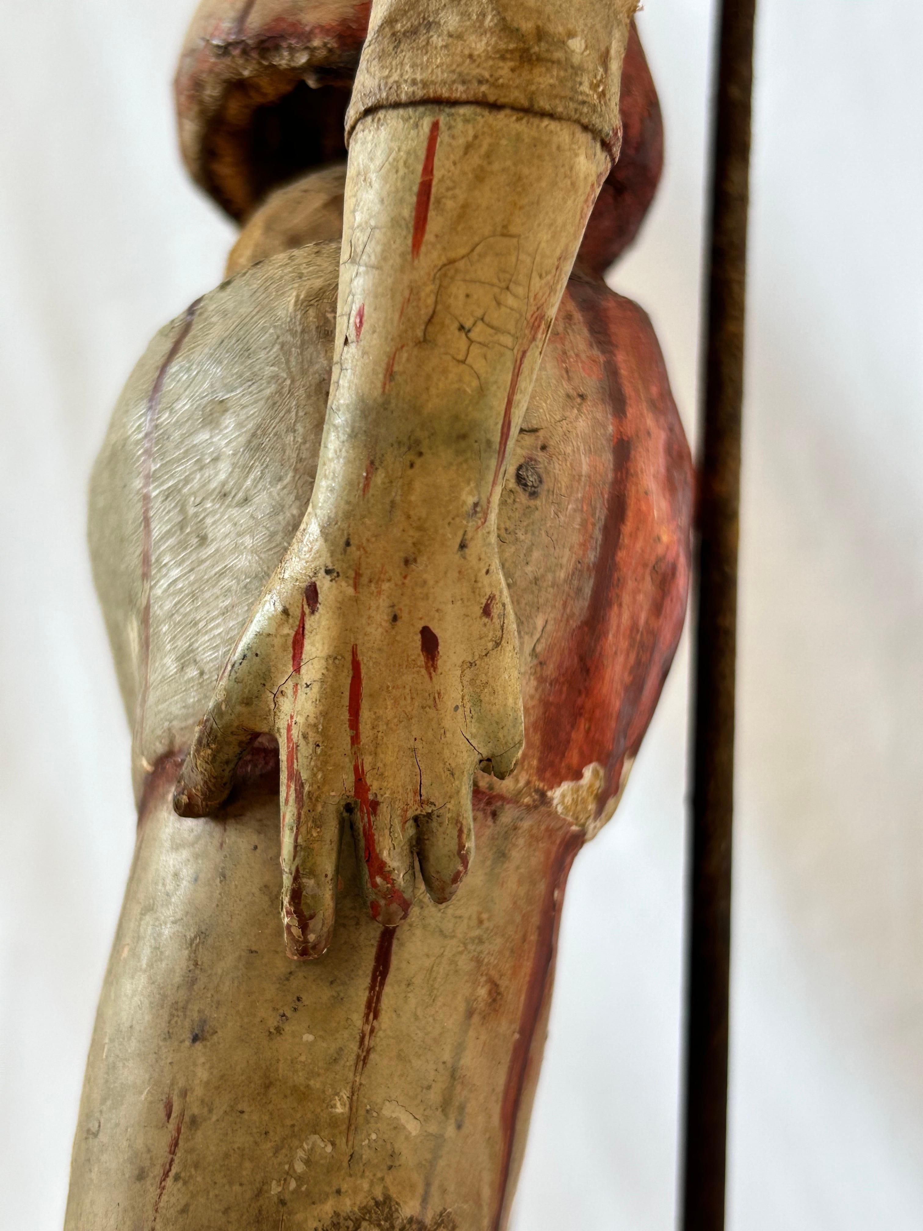 An antique, circa late 17th Century Italian Santos reliquary figure in relic form presented on a custom stand of a later date. The figure is presented in wood, possibly pine, as a realistically hand carved jointed form with a gesso overlay and a