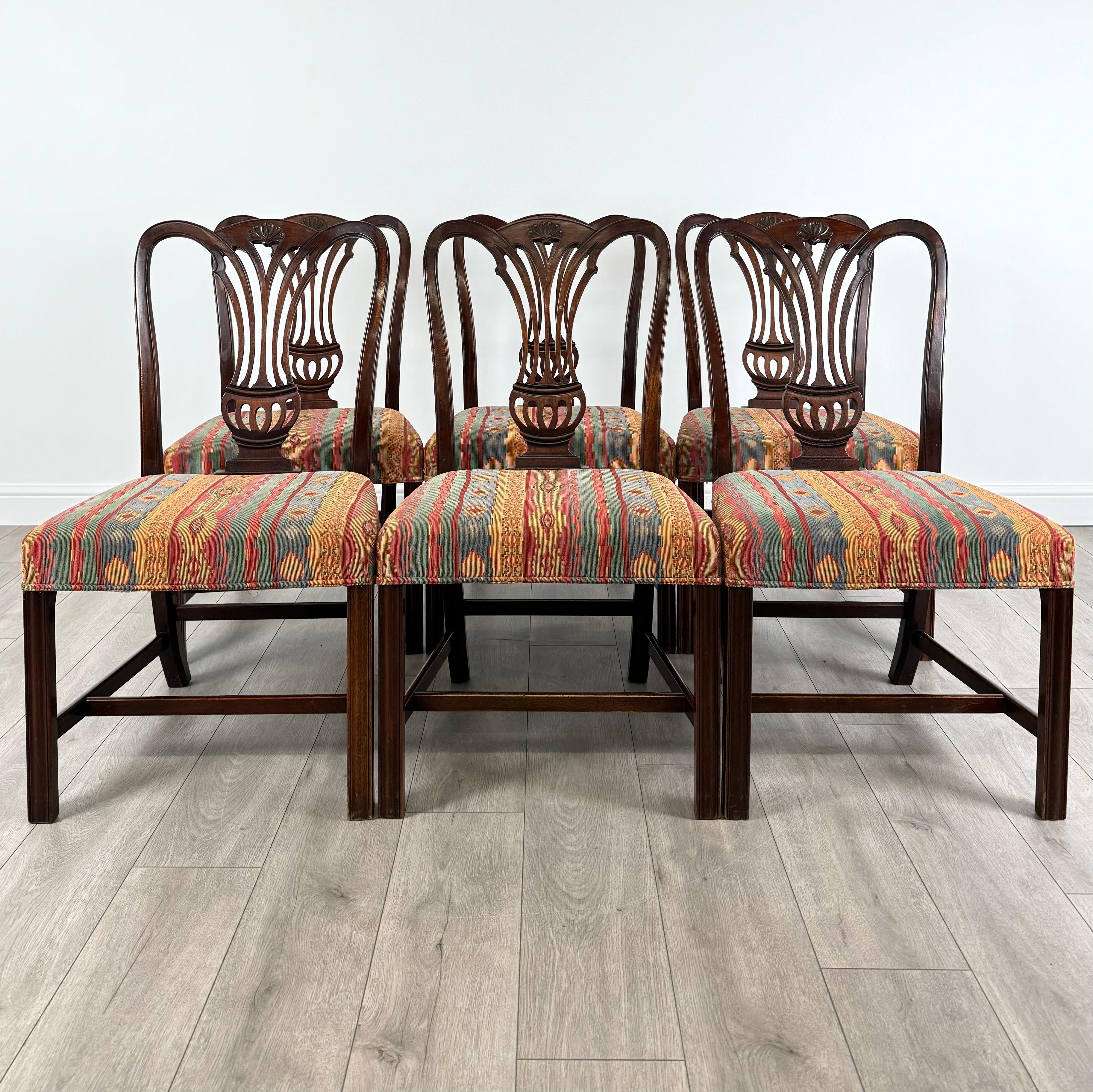 Ce superbe ensemble de 6 chaises de salle à manger antiques du XVIIIe siècle est fabriqué à partir d'un riche acajou, ce qui témoigne d'une qualité et d'un savoir-faire exceptionnels. Les dossiers joliment décorés présentent des sculptures subtiles