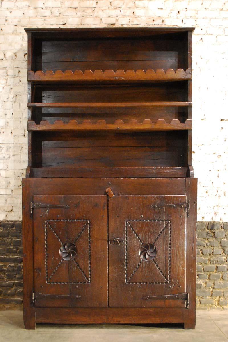 A beautiful hand carved solid oak kitchen cabinet
It has a recessed upper part for the display of plates and cups. The lower cabinet features a fixed shelf and the doors are decorated with geometric chip carving and rosettes. The cabinet has a rural